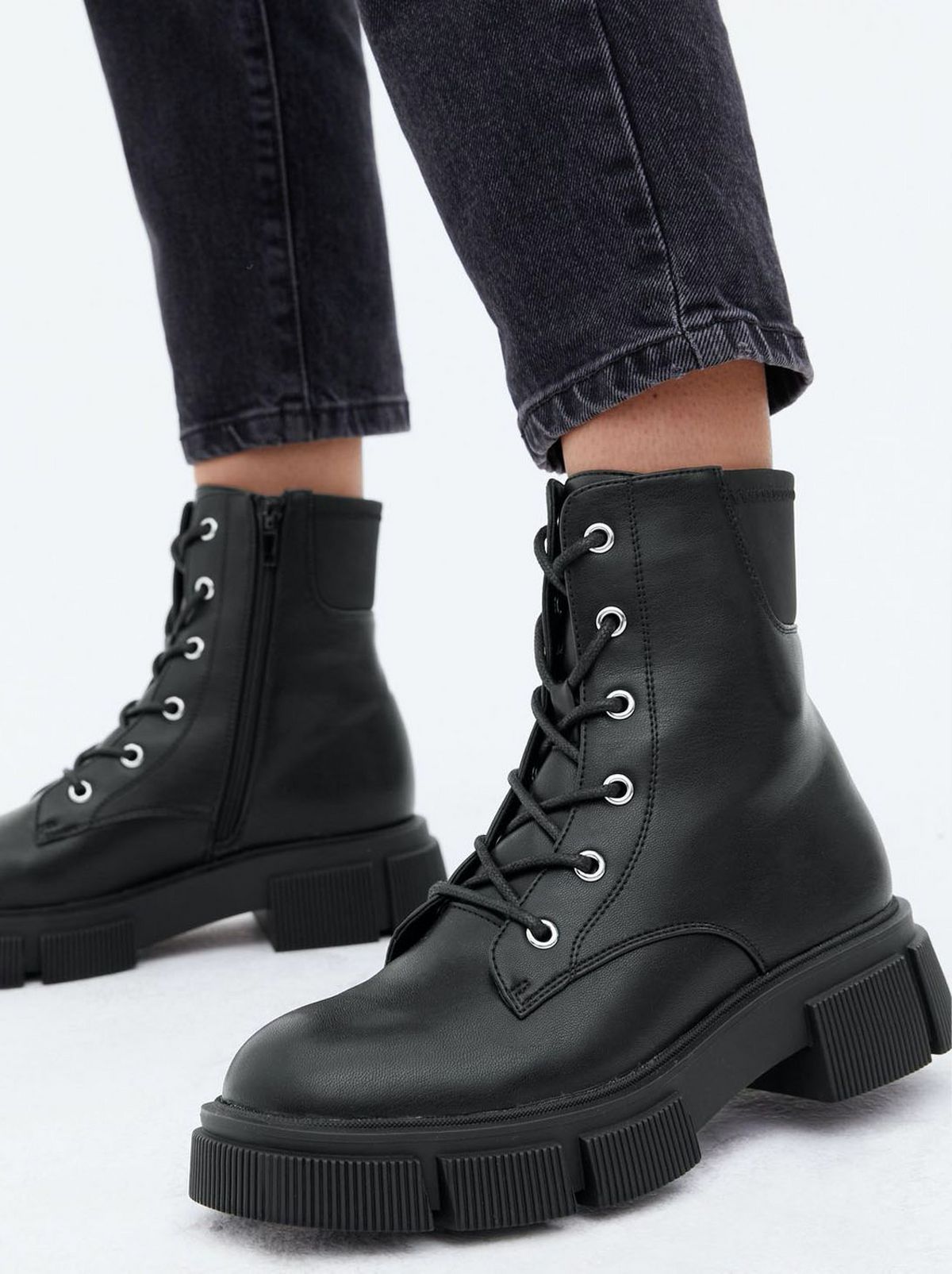 Woman wearing black lace up chunky boots