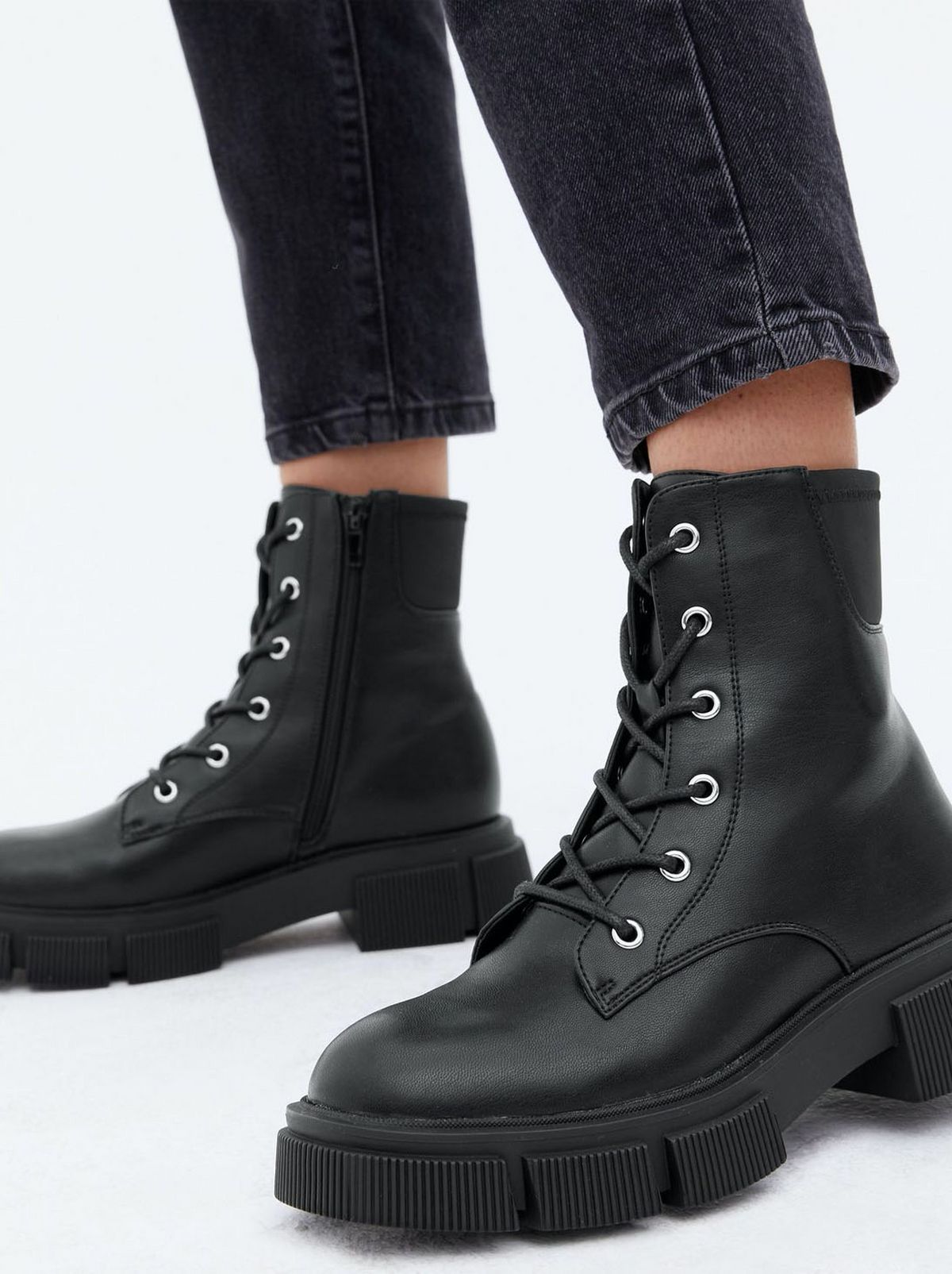 Woman wearing black lace up chunky boots