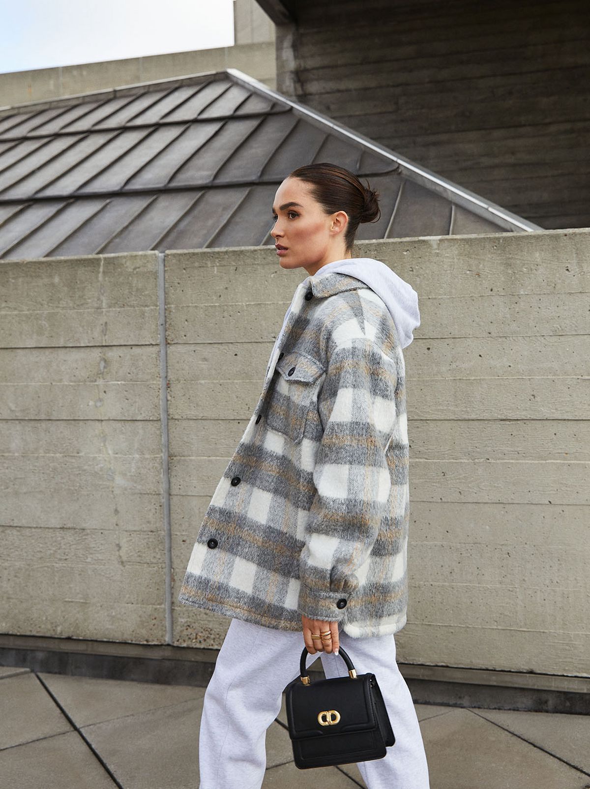 Lissy Roddy wearing a check overcoat, hoodie and white trousers