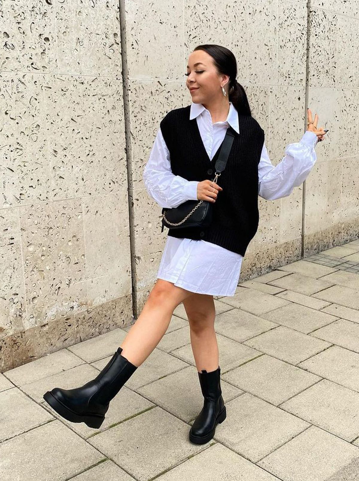 New Look's Ella wearing a black ribbed knit button long sleeveless vest