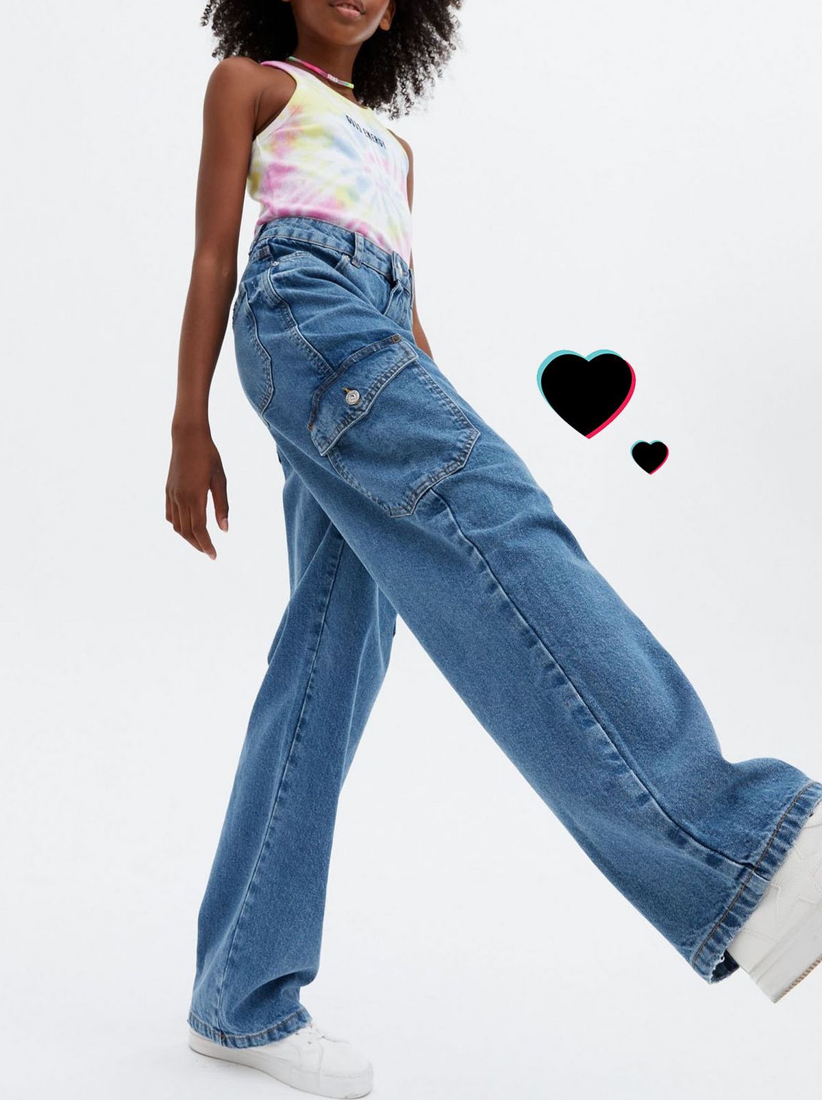 Girl wearing blue cargo pocket baggy fit jeans, top and trainers	