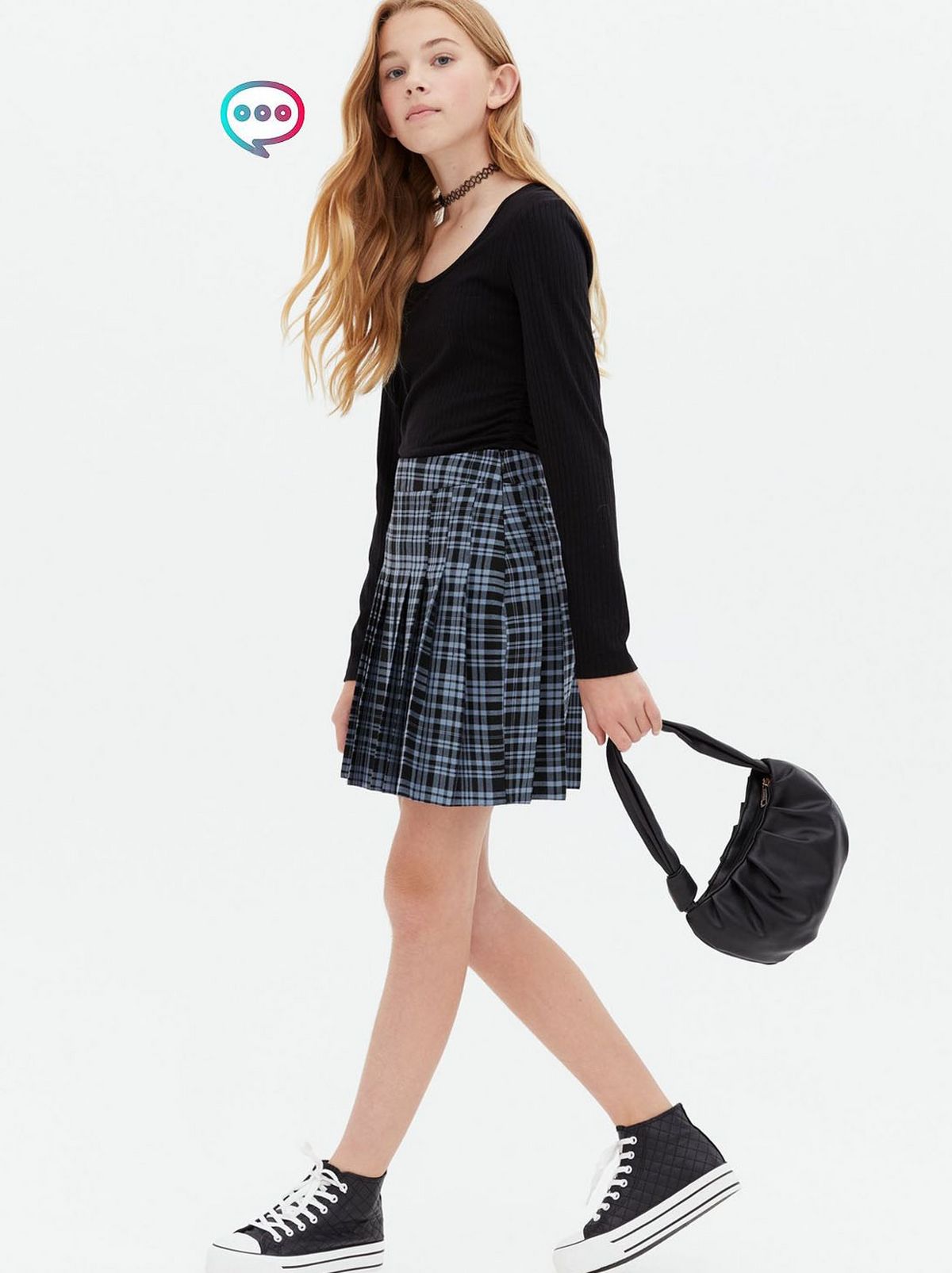 Girl wearing a blue check pleated mini tennis skirt, top and trainers	
