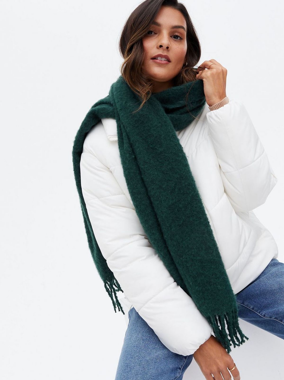 Woman wearing a green tassel trim scarf	
