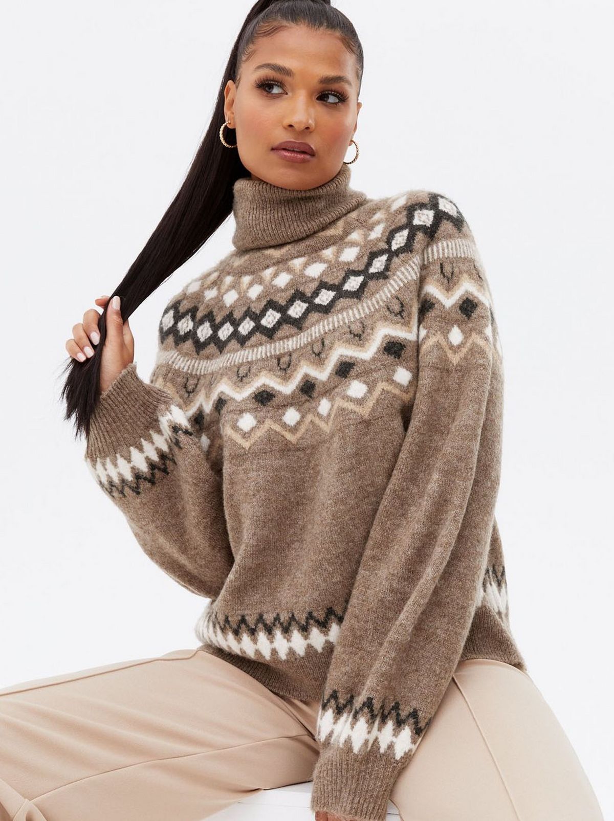 Woman wearing a brown fair isle roll neck jumper	