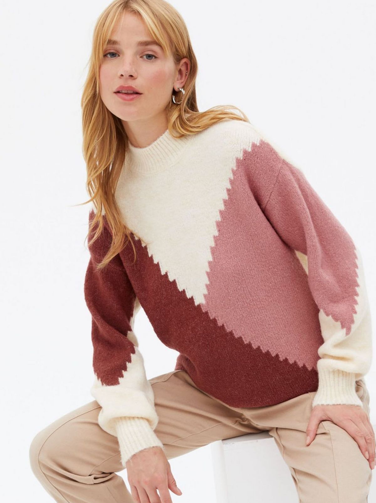 Woman wearing a pink diagonal color block jumper	