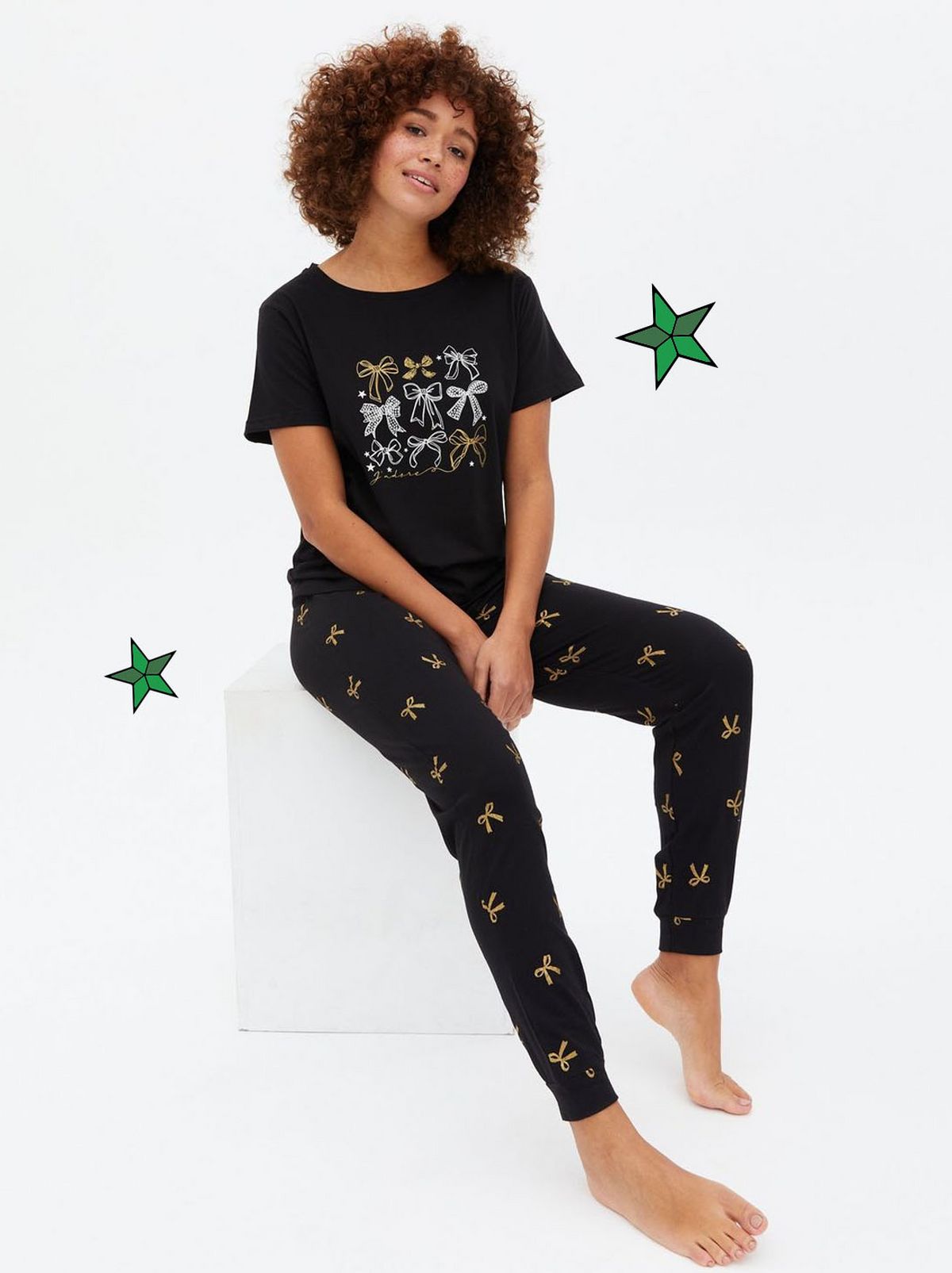 Woman wearing a black jogger pyjama set with bows	