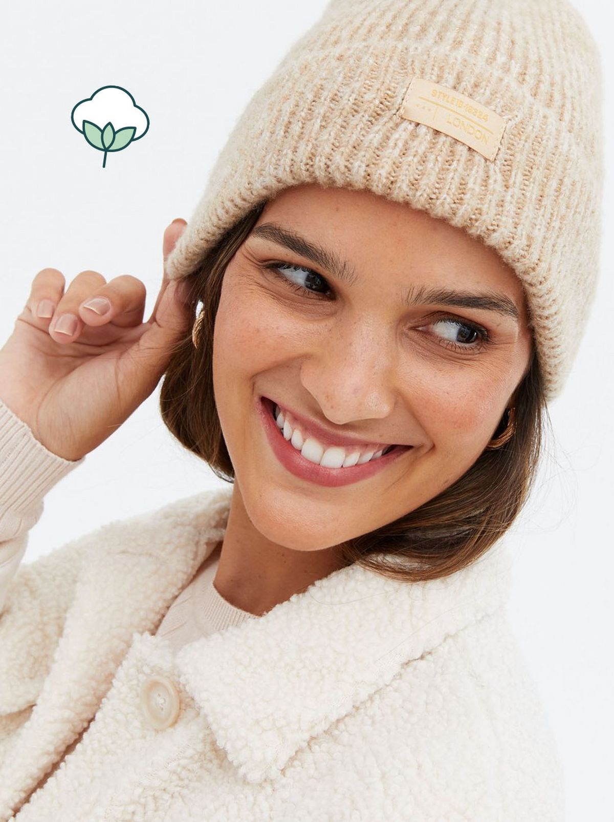 Woman wearing a camel ribbed tab front beanie