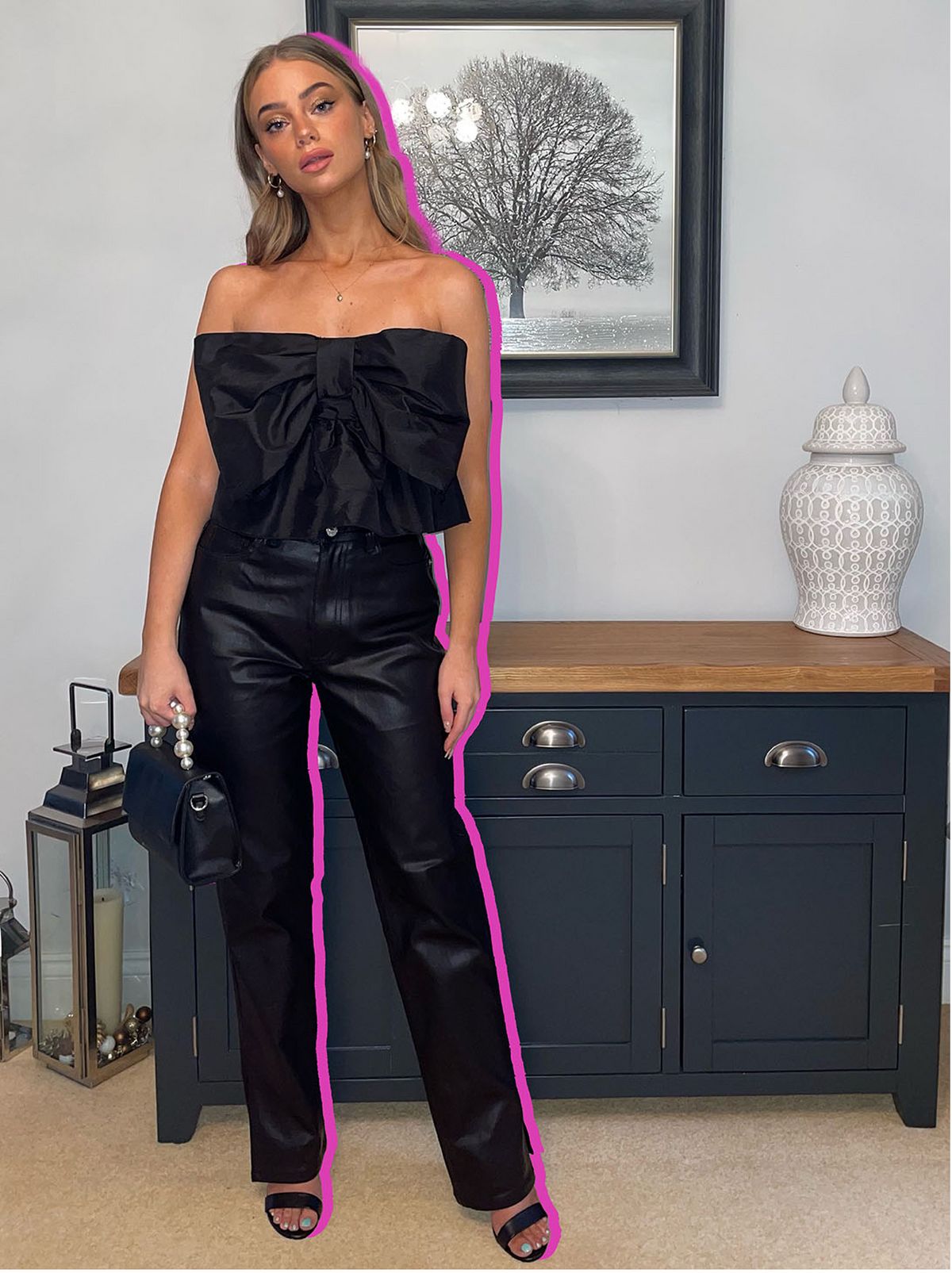 Emily wearing a black bow sleeveless top and leather look pants	