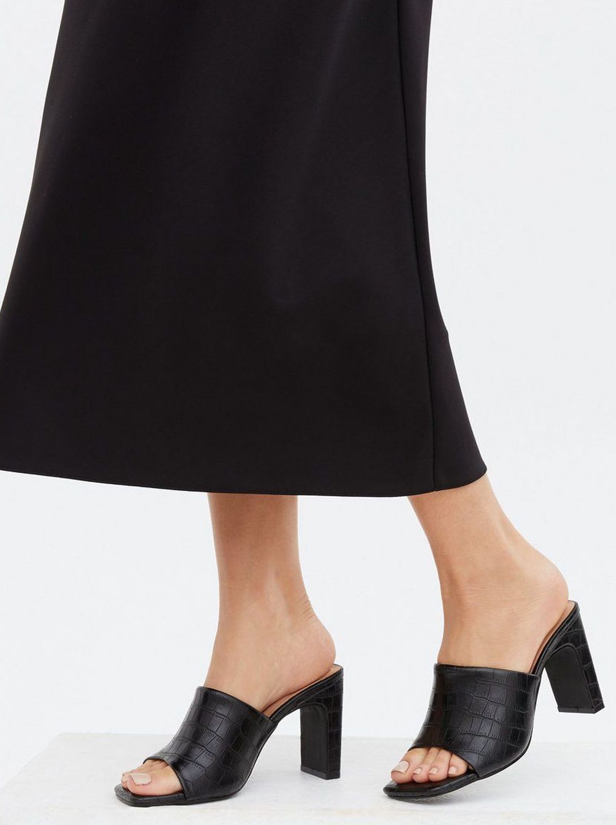 Woman wearing a black faux fur block heel mules