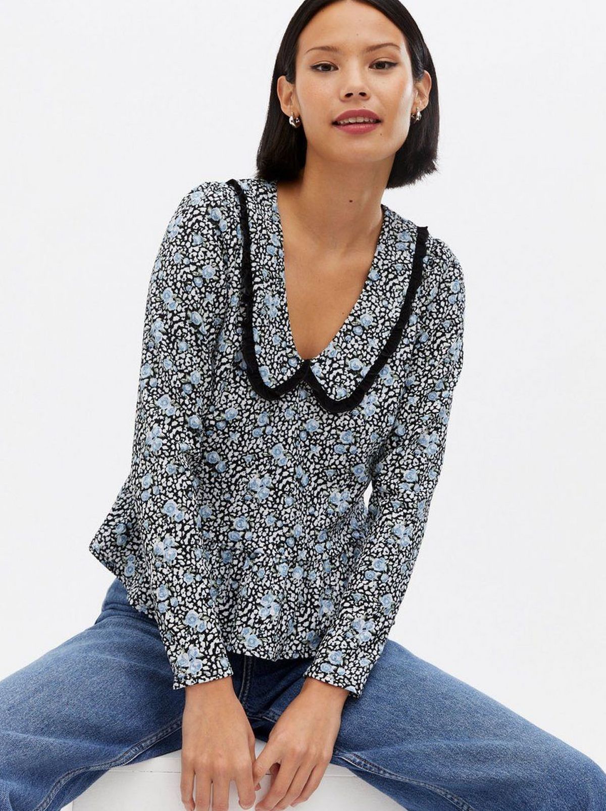 Woman wearing a blue floral frill collar blouse
