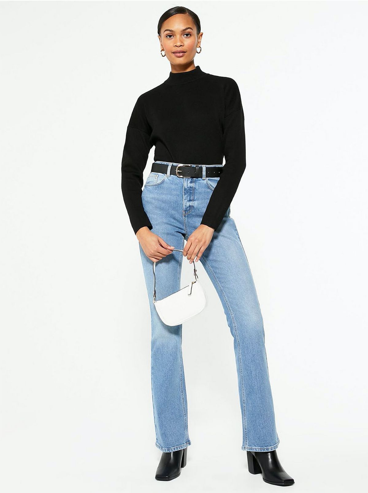 model wears black long-sleeve top and blue flared jeans