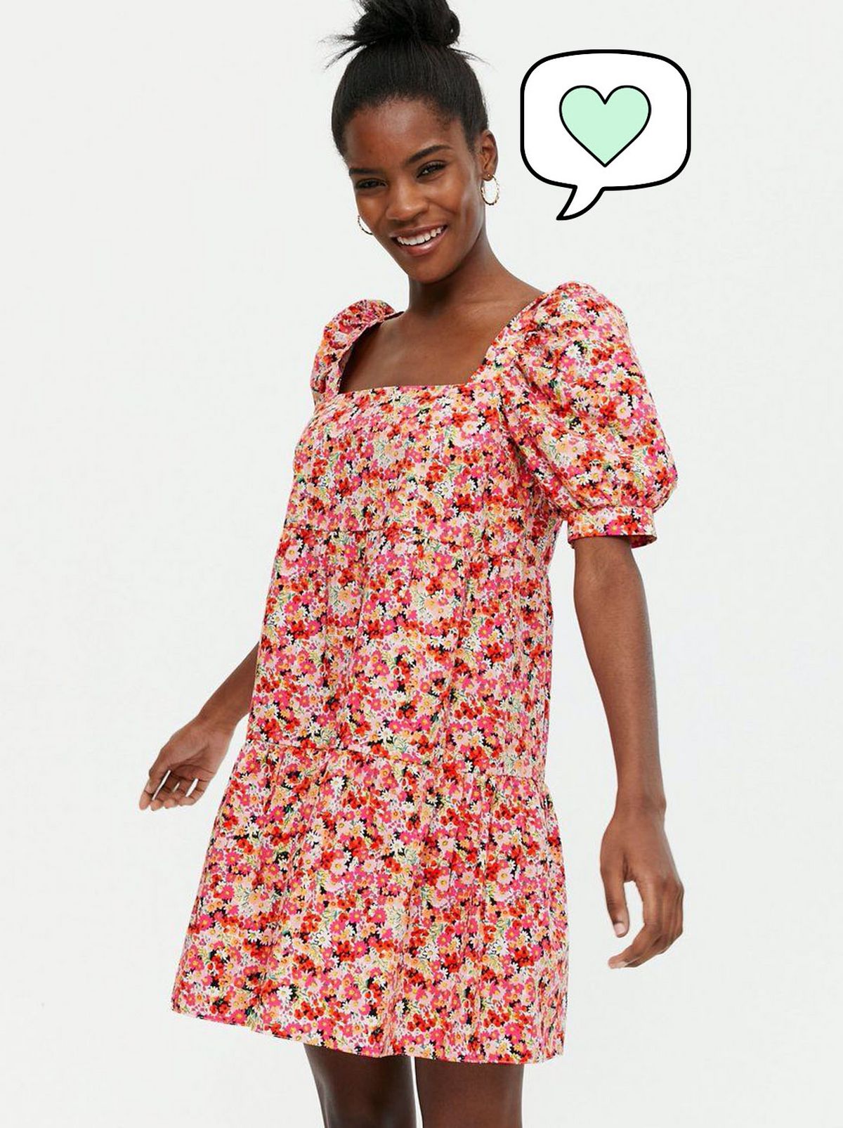 Woman wearing a pink floral square neck mini smock dress