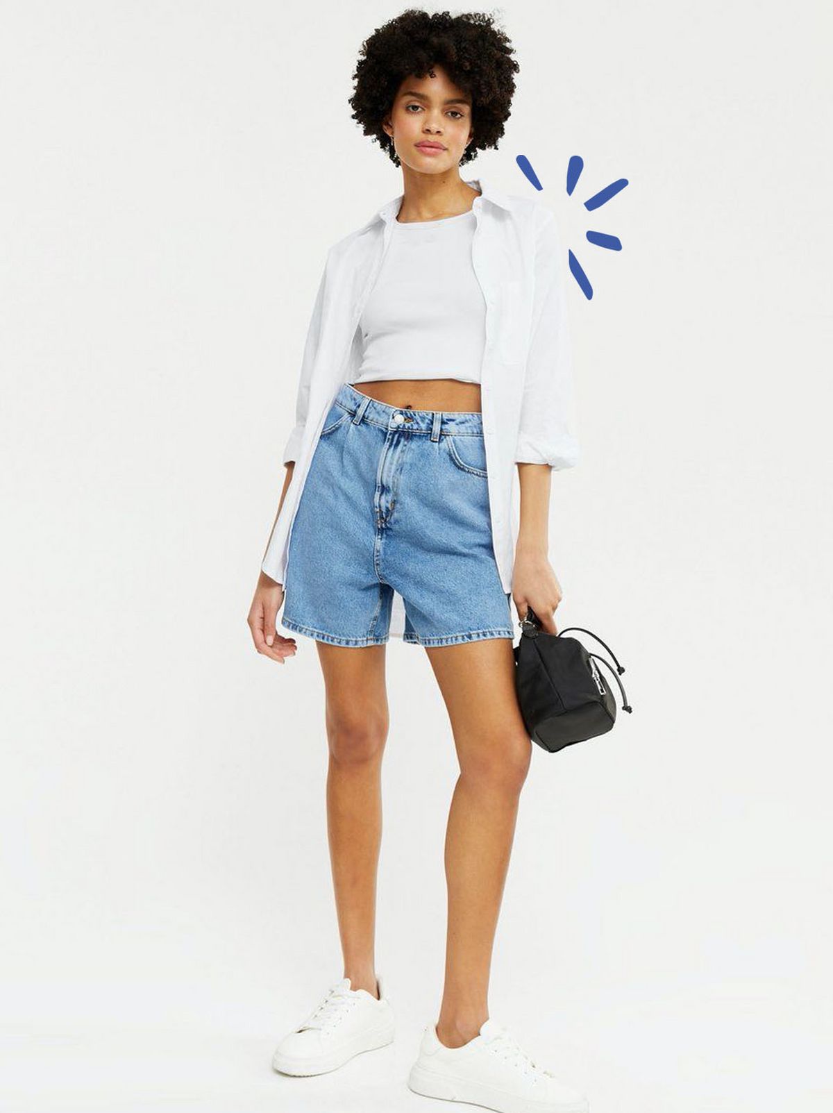 Woman wearing blue denim pleated shorts, white crop top and white shirt