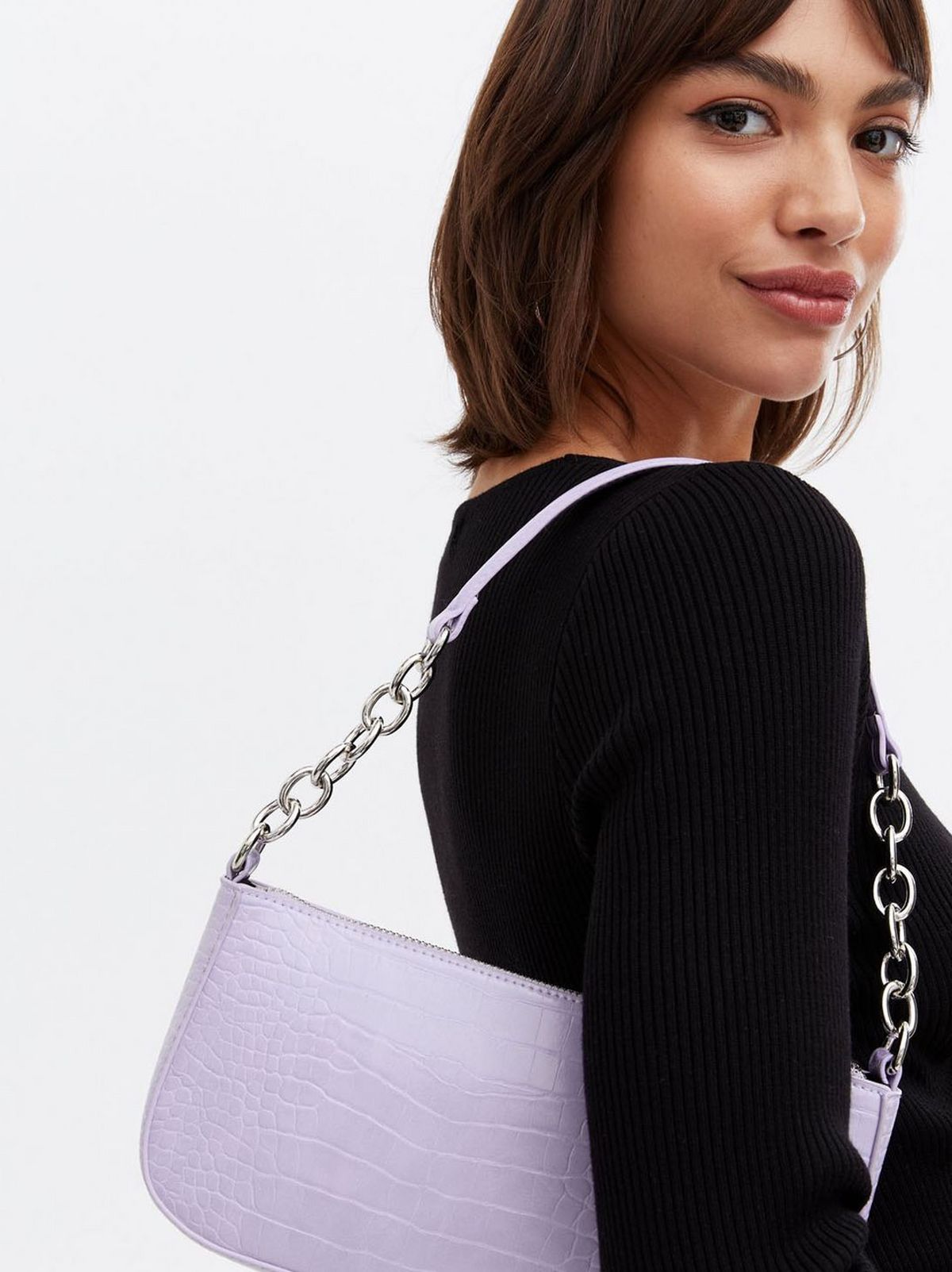 Woman wearing a lilac faux croc chain shoulder bag