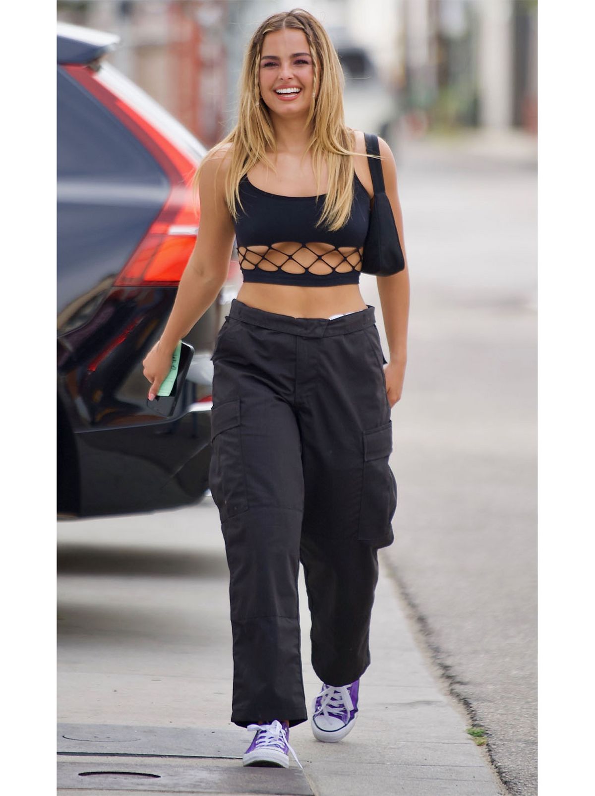 Madison Beer wearing black trousers and a black crop top