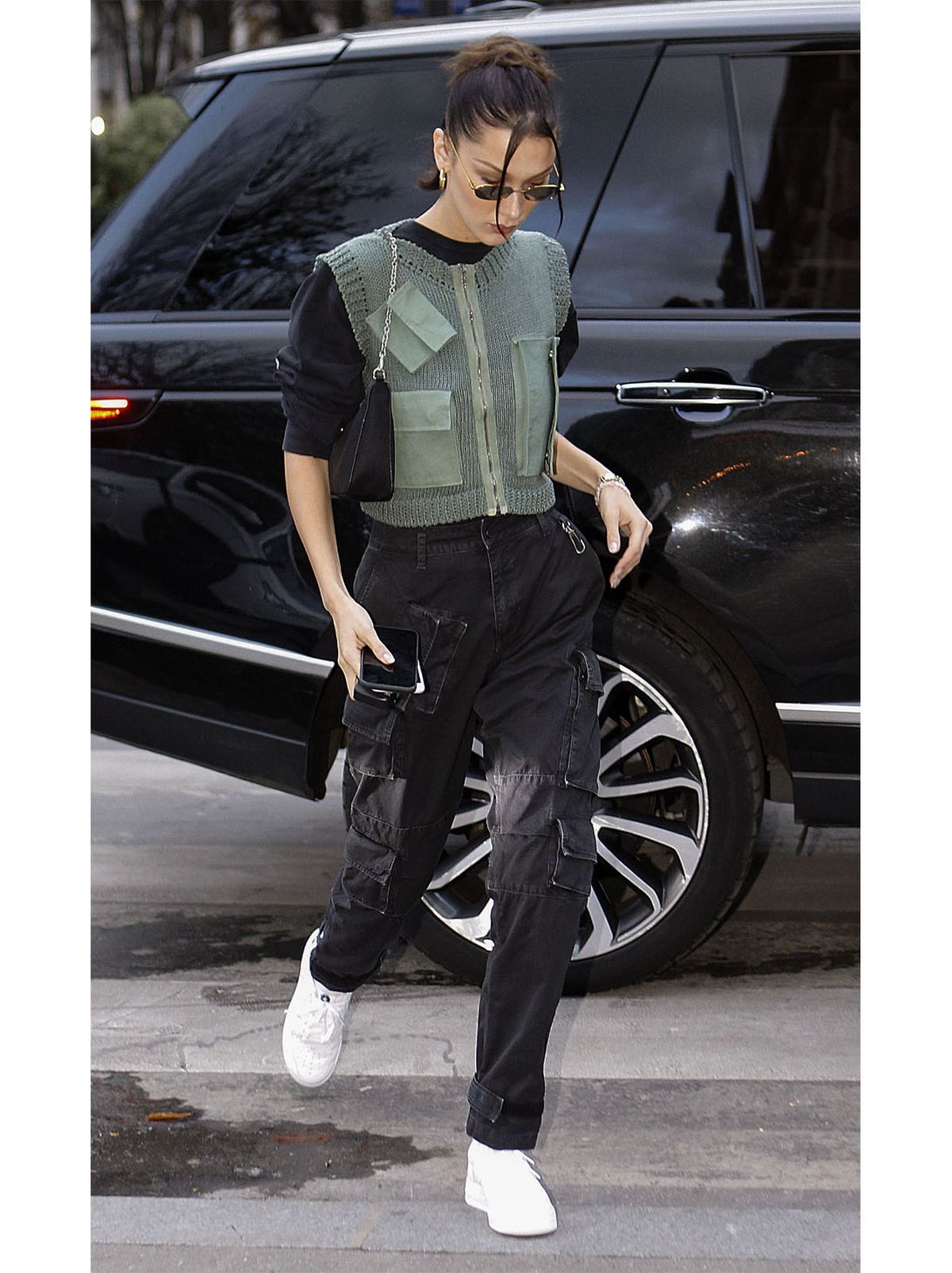 Bella Hadid wearing a black top and black cargo pants