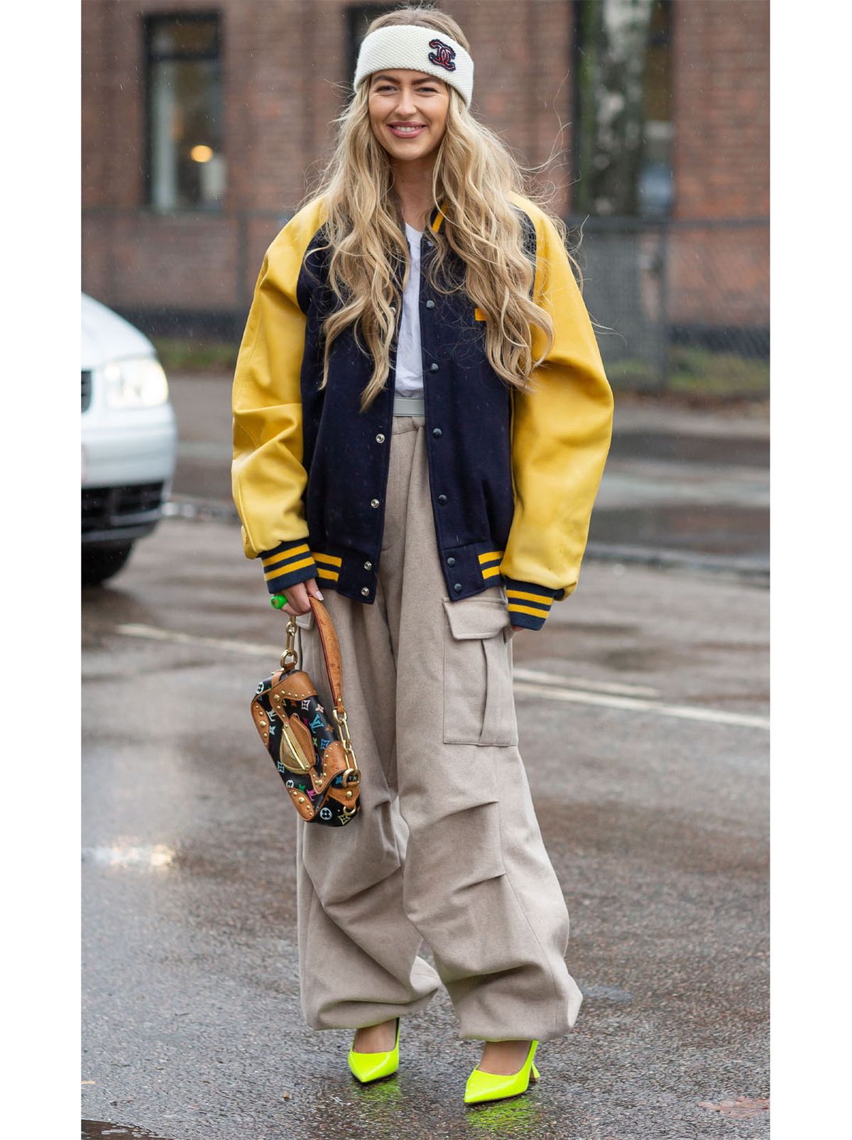 Emili Sindlev wearing cream trousers and a varsity jacket