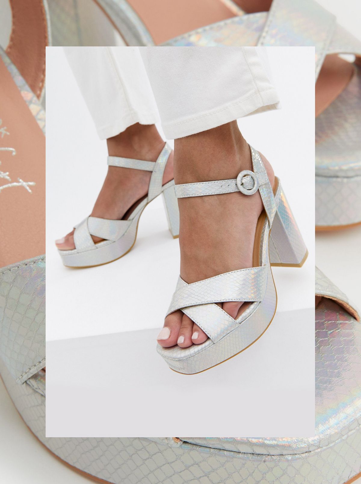 We see a pair of silver block heel chunky platform sandals being worn by a person in front of a white background