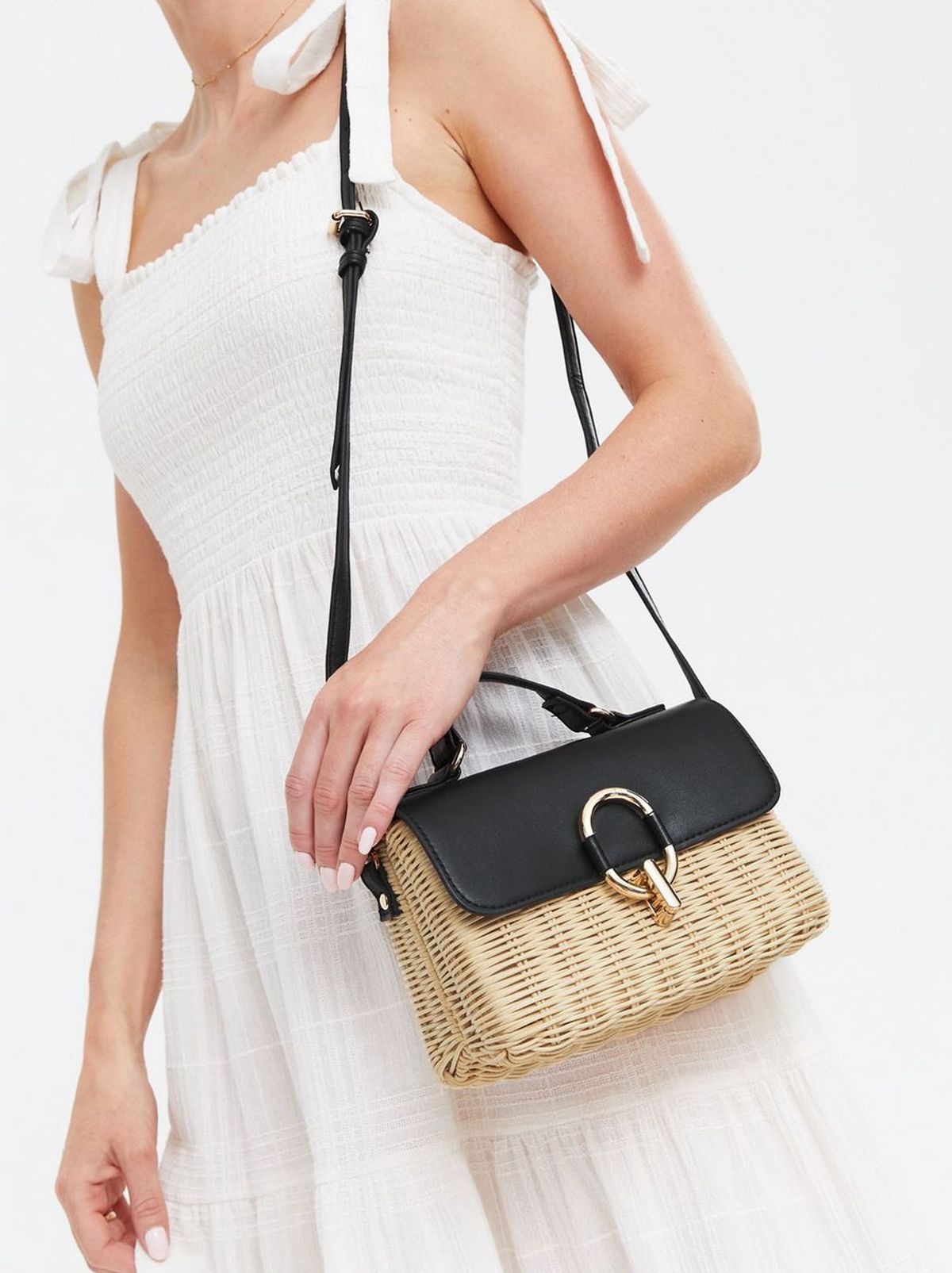 We see a person wearing a white dress and a cross body bag