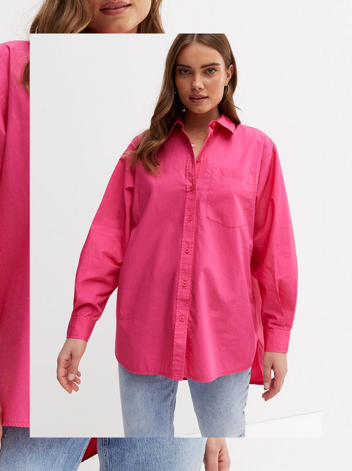 A women stands in front of a white background wearing a pink oversized shirt and a pair of skinny jeans