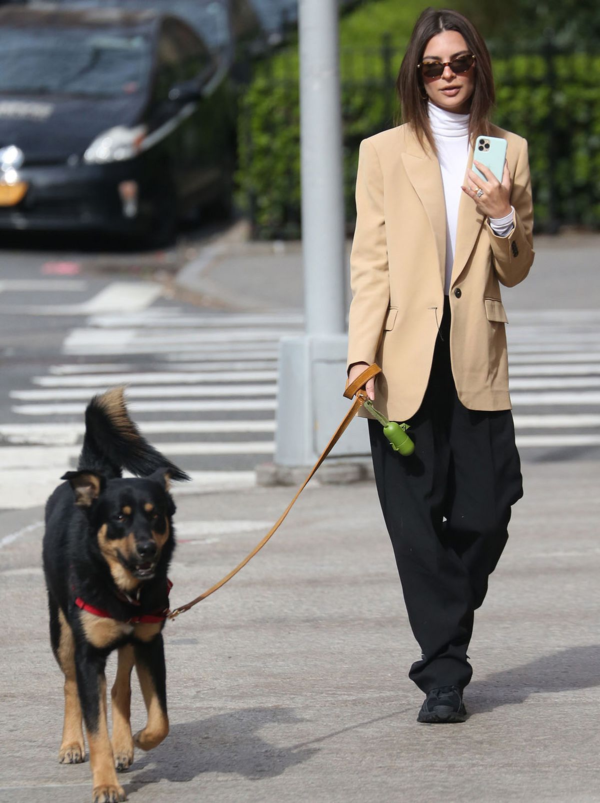 Emily Ratajkowski, walking her dog, wearing a cream blazer, black trousers and shoes