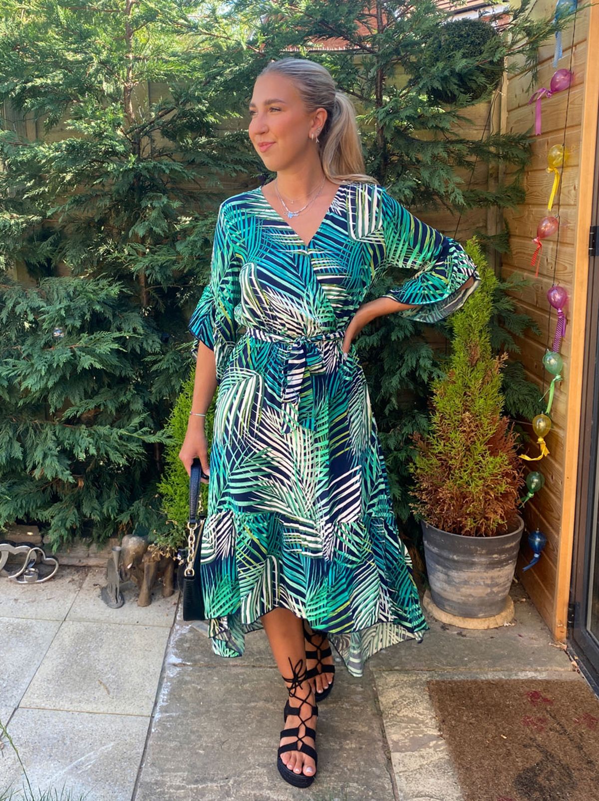 New Look's Agata stands in a garden wearing a patterned midi dress from Apricot