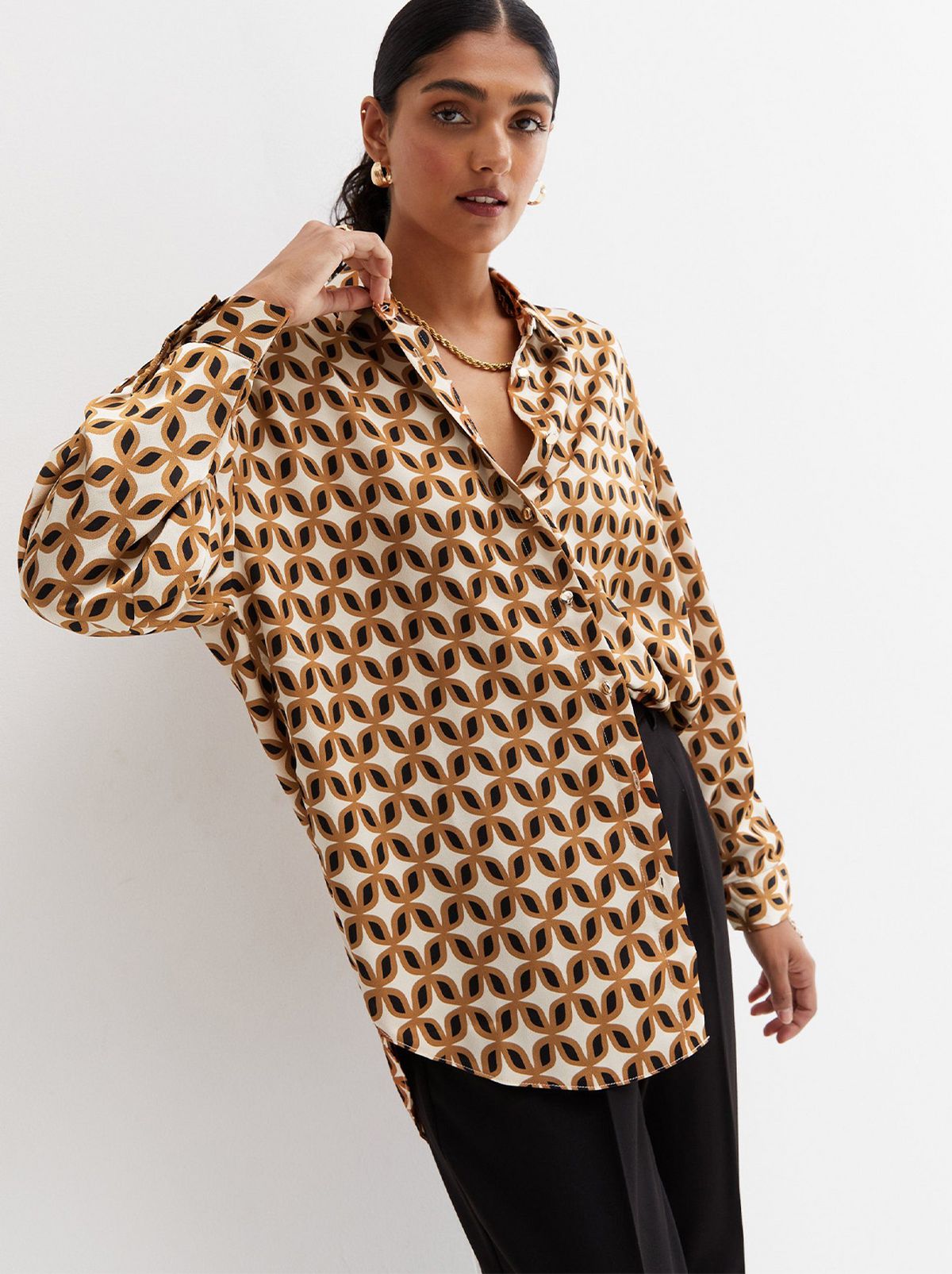 Woman wearing a brown geometric long sleeve shirt and trousers