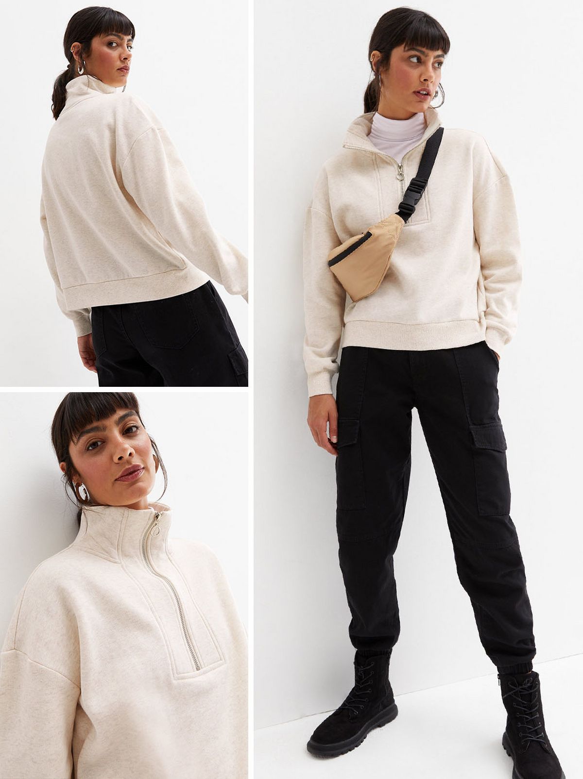 A model is standing looking at the camera in front of a white background wearing a cream half zip sweatshirt and a pair of black trousers