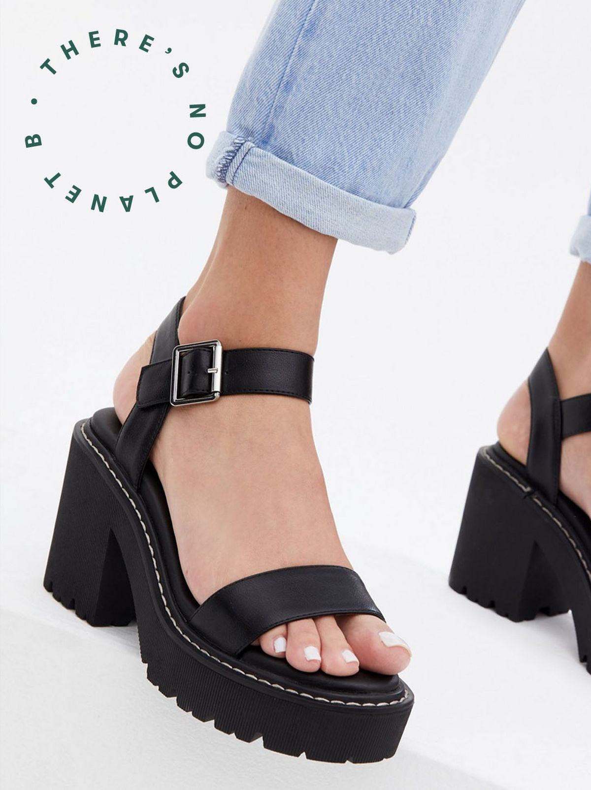 Woman wearing black leather look block heels sandals 