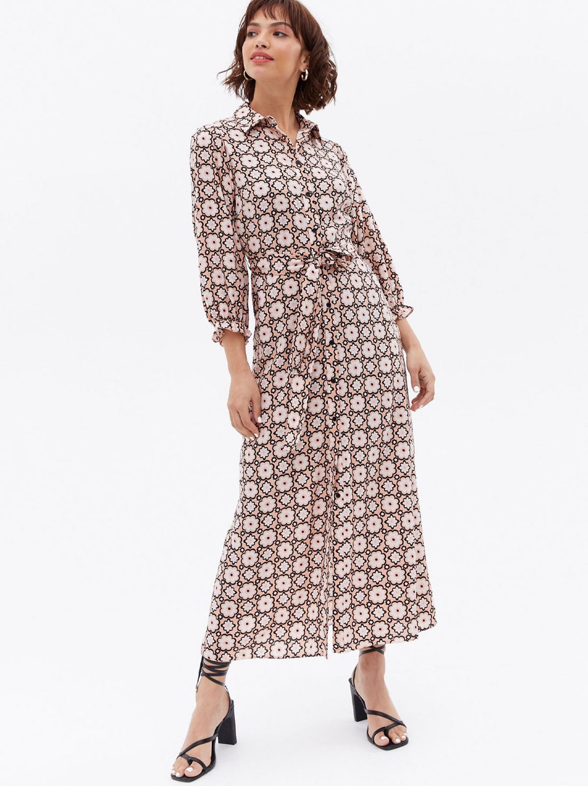 Woman wearing a pink geometric tie waist shirt dress