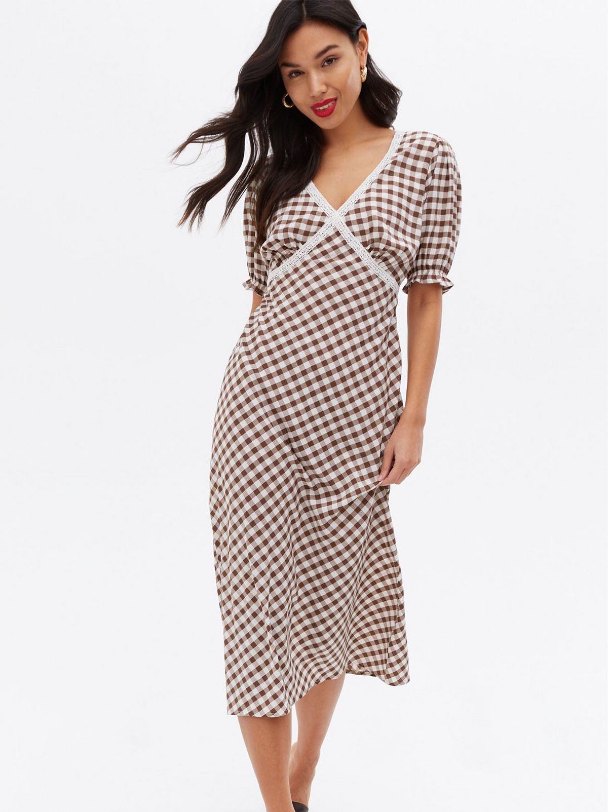Woman wearing a brown gingham v neck midi dress