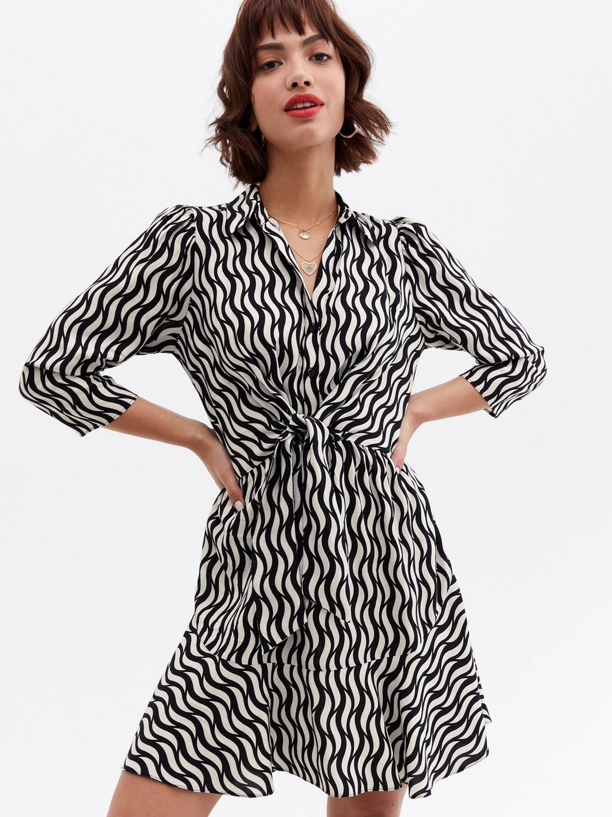 Woman wearing a black swirl mini shirt dress