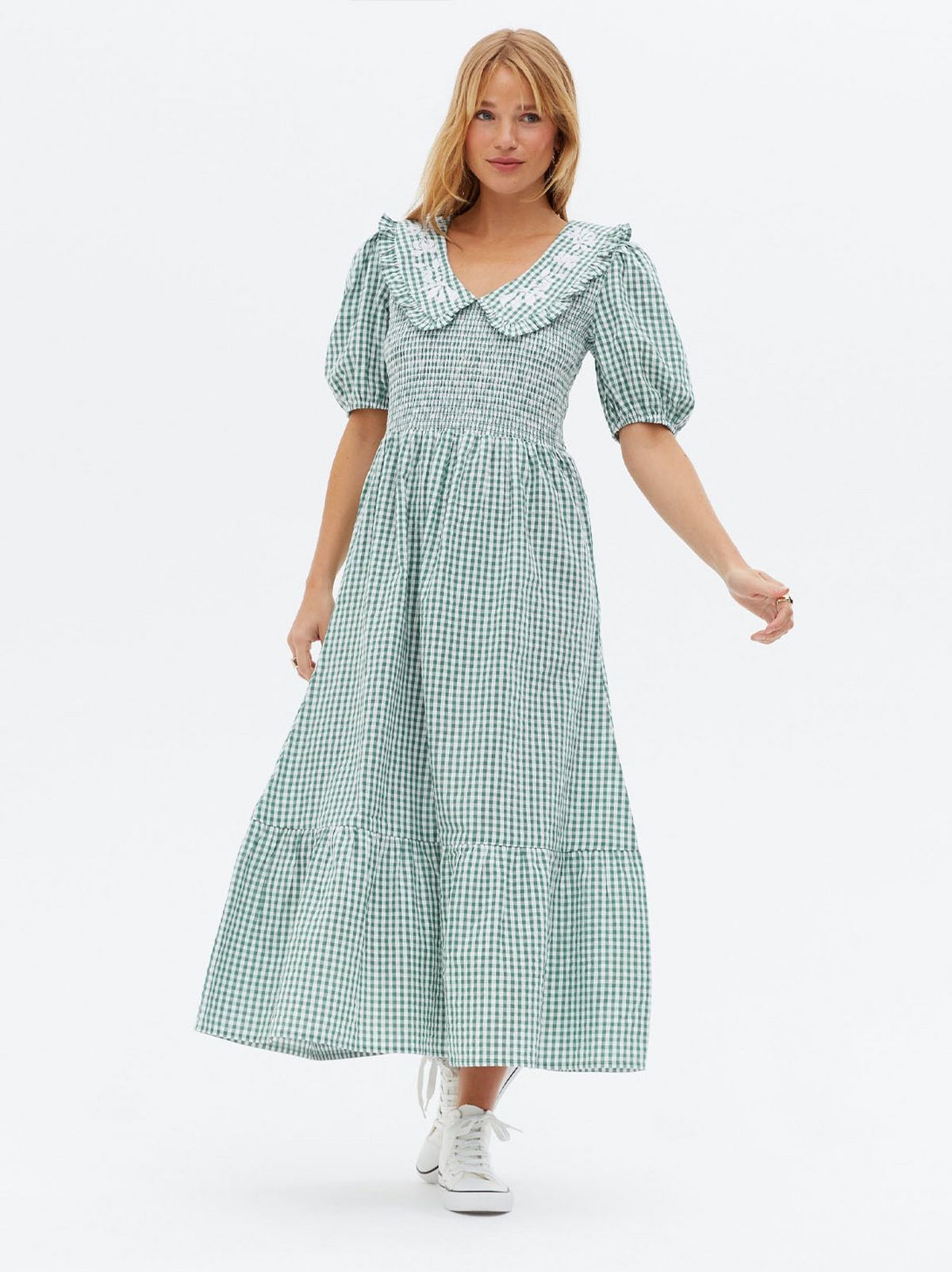 Woman wearing a green gingham shirred midi dress