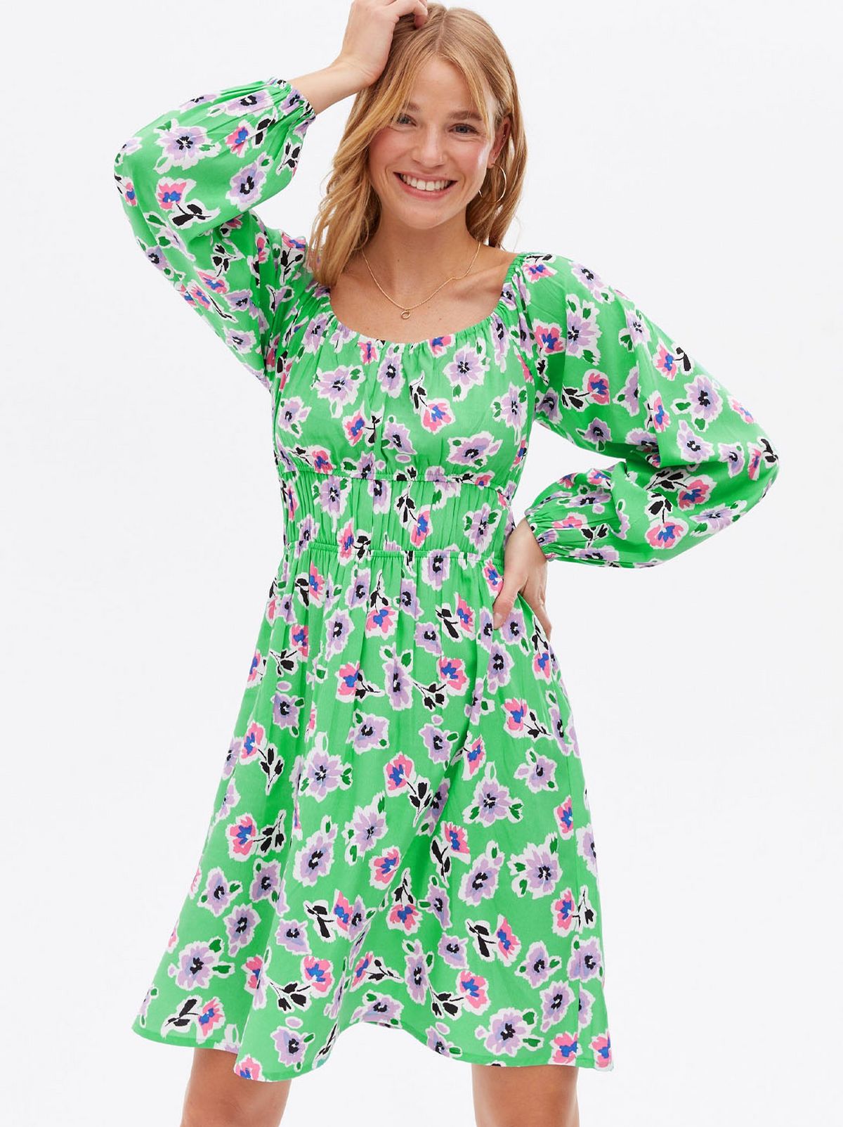 Woman wearing a green floral ruched mini dress