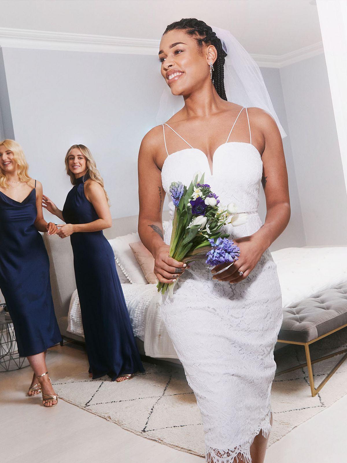 Women wearing navy dresses and a wedding dress