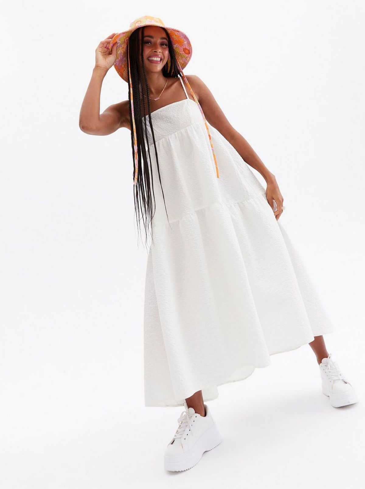 Woman wearing a white tiered strappy midi dress