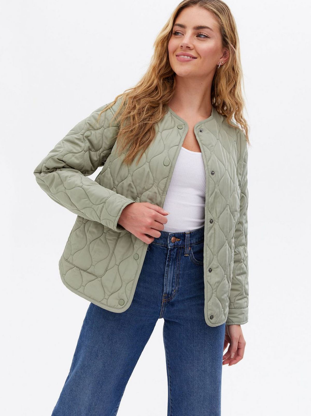 Woman wearing a khaki quilted collarless jacket