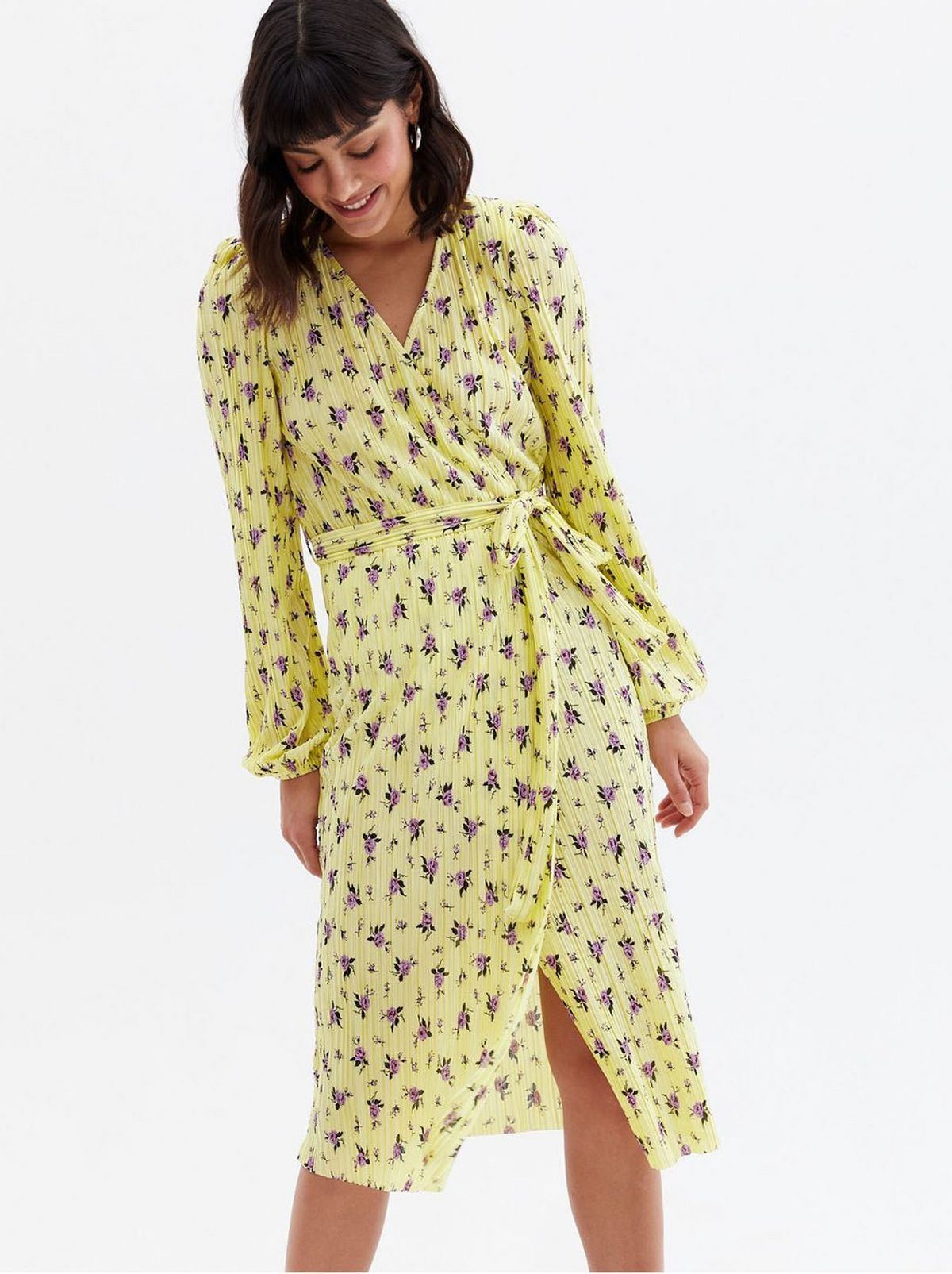 Woman wearing a plissé belted midi wrap dress