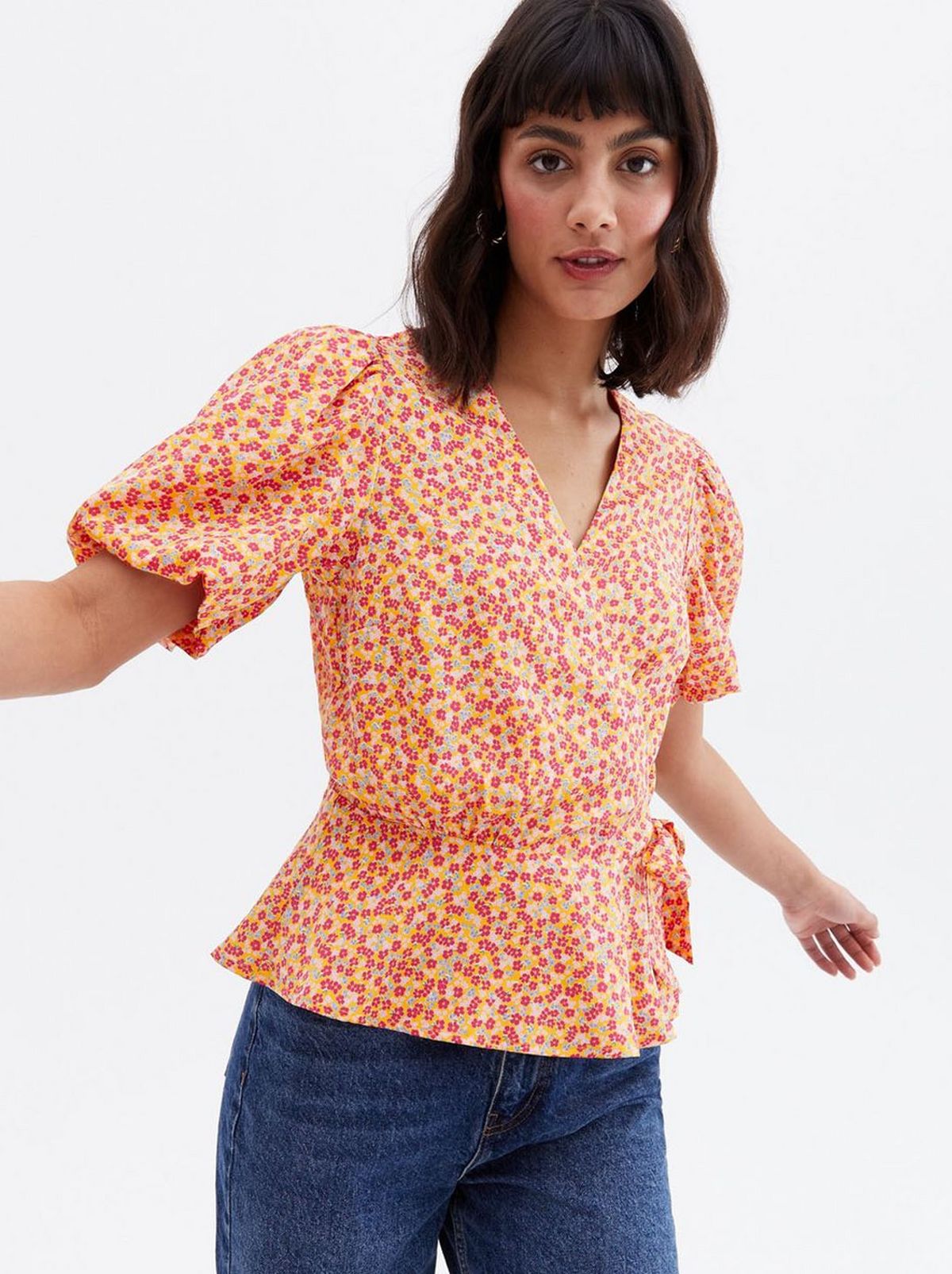 Woman wearing a ditsy floral crepe peplum wrap blouse
