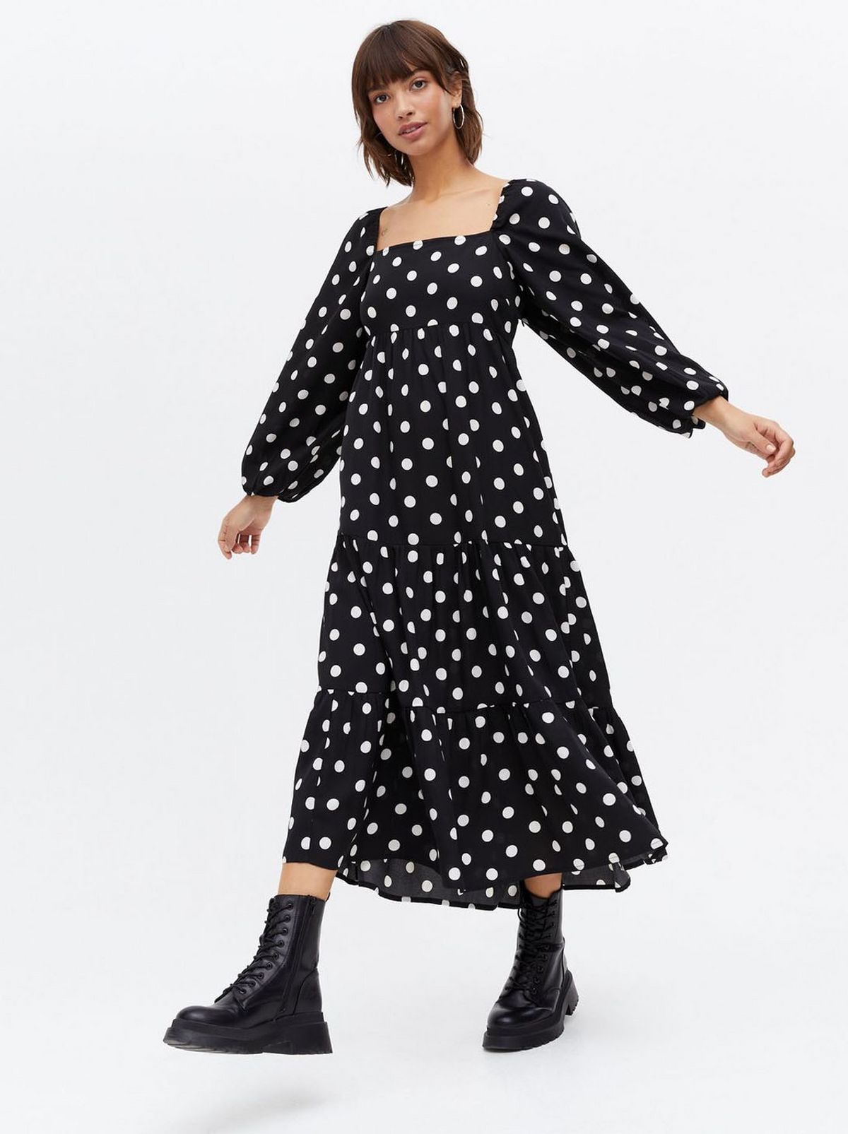 Woman wearing a black spot square neck tiered midi dress