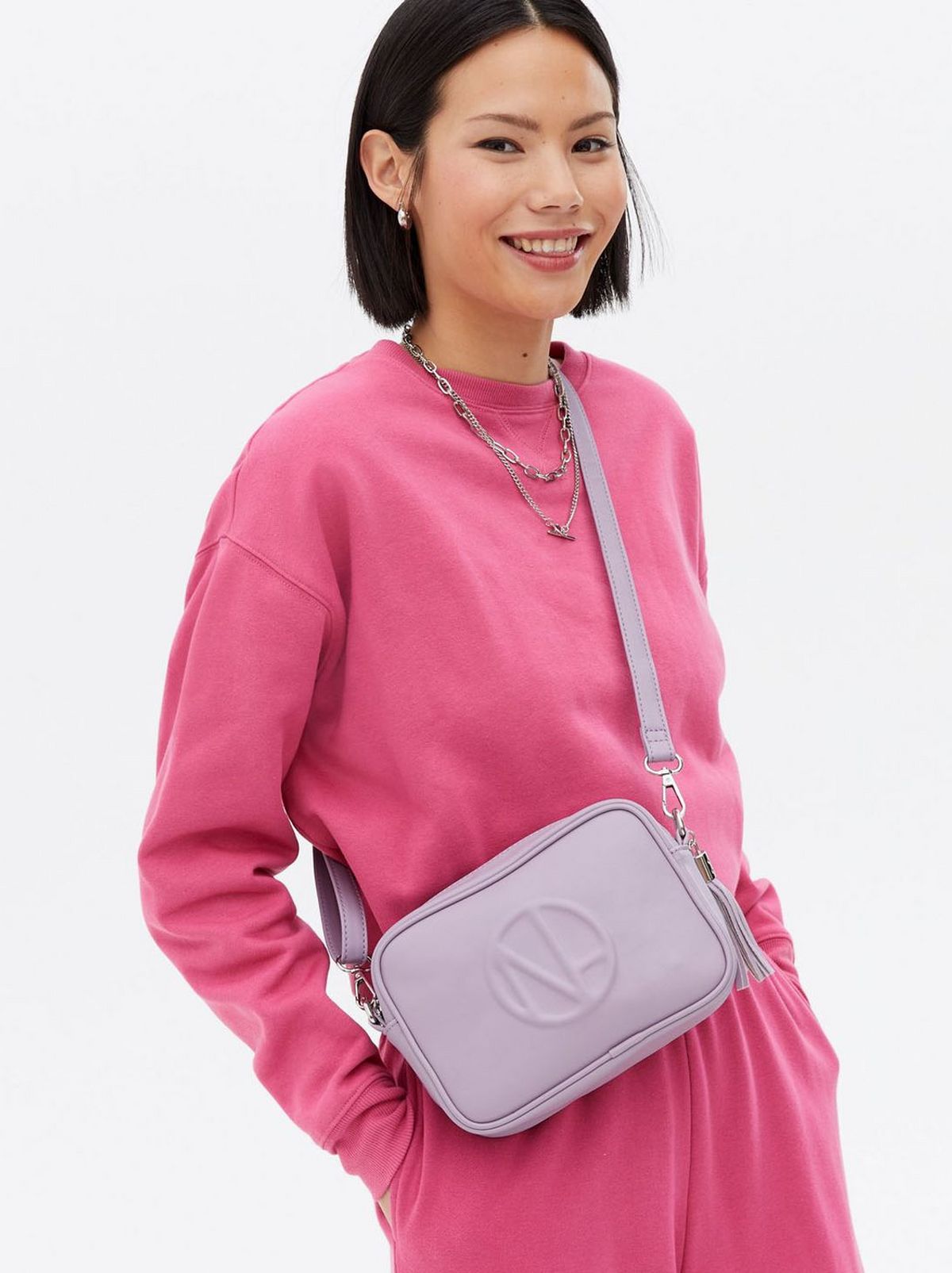 Woman wearing a lilac leather look embossed cross body bag