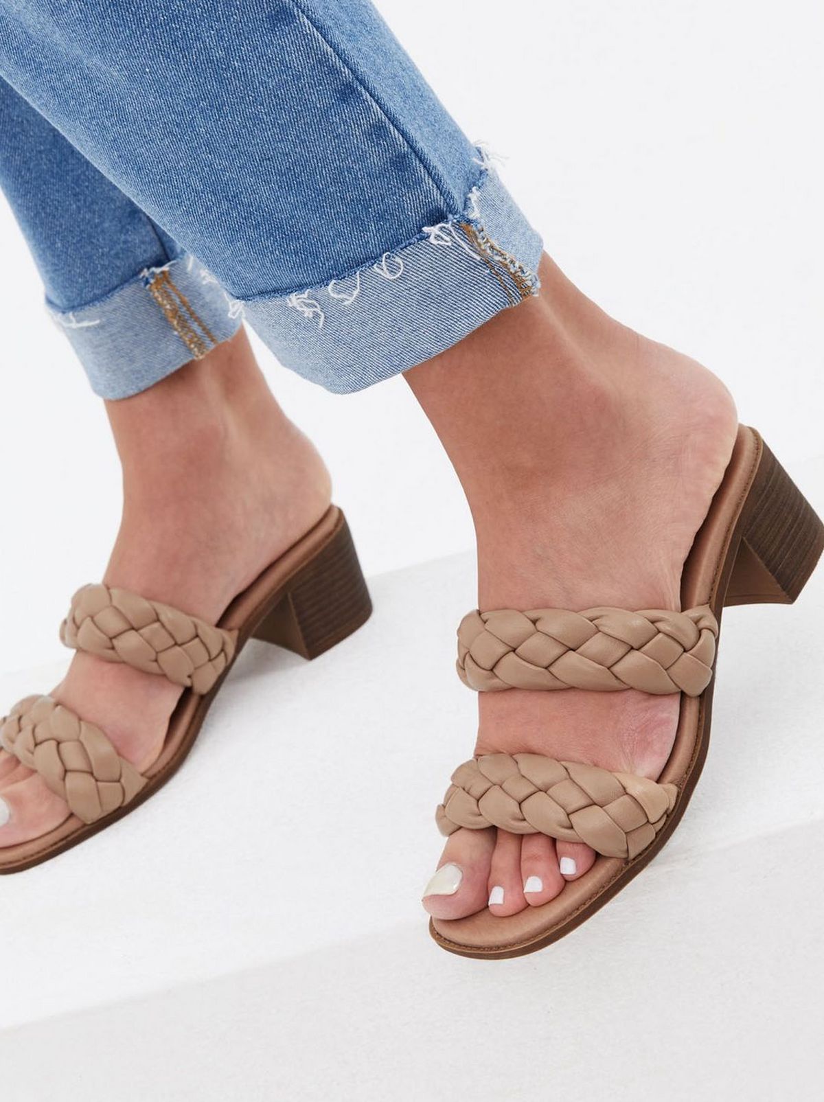 Woman wearing camel plaited double strap block heel mules