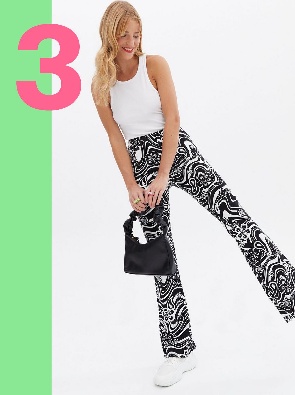 Woman wearing black floral swirl flared trousers