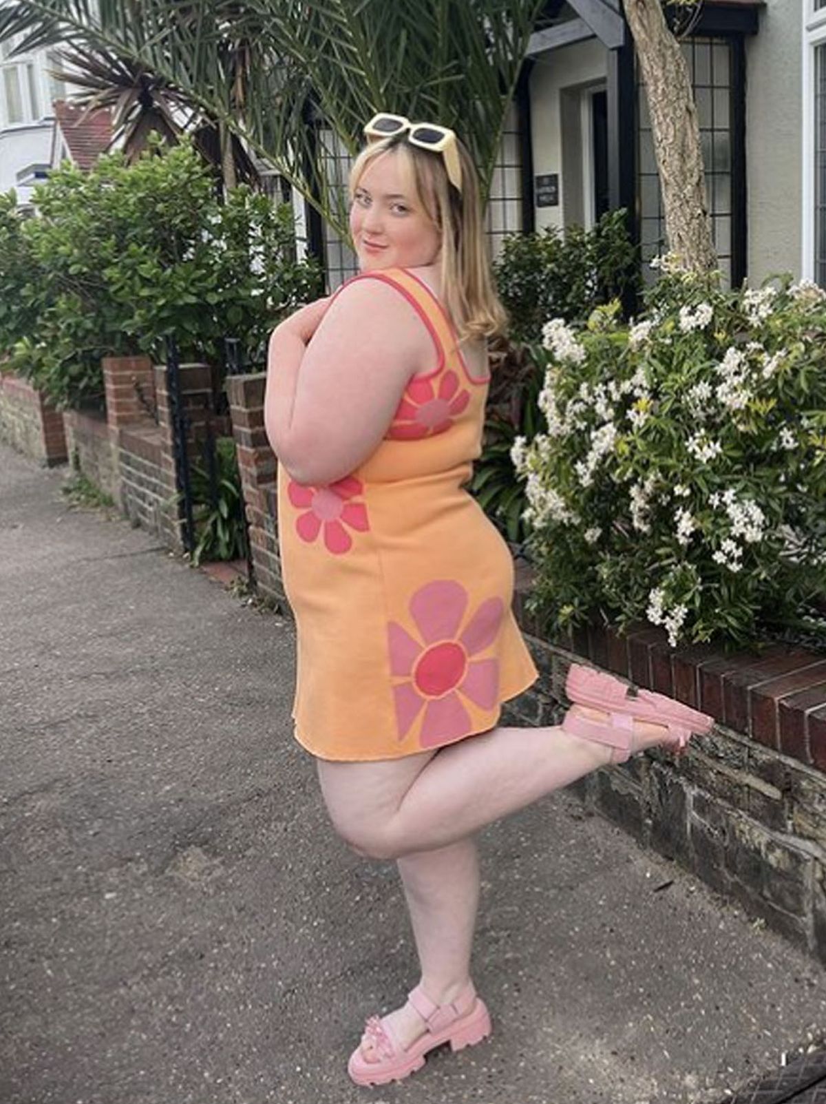 @amelia.bashfordx wearing an Anne-Marie floral orange dress