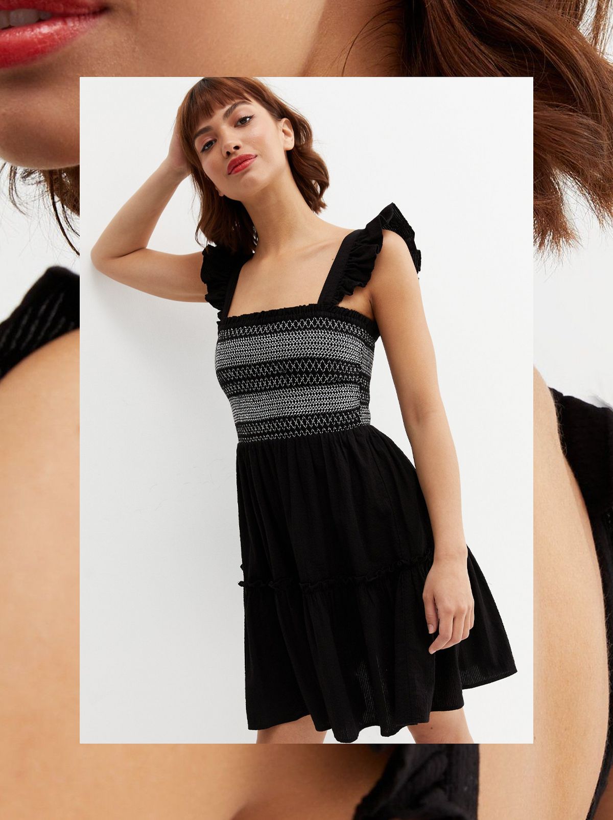 A women leans on a blank wall wearing a black patterned frill mini dress