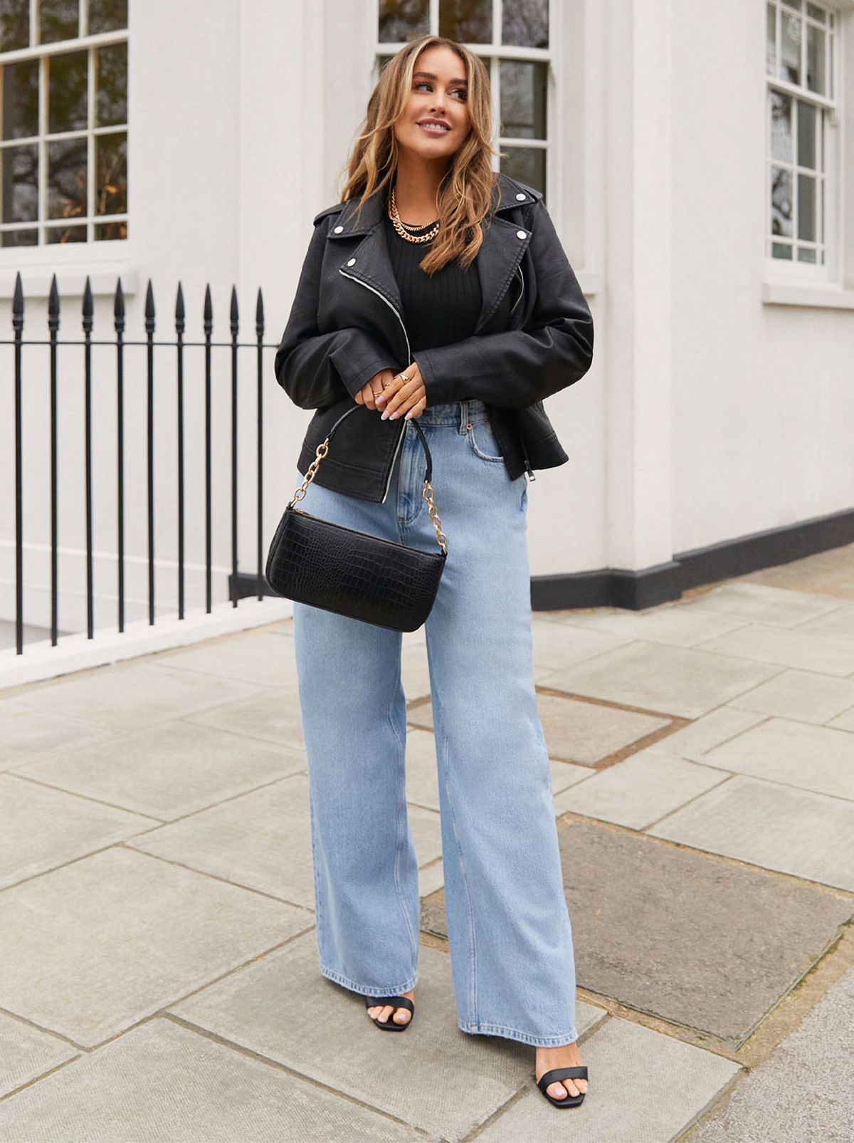Sophie Milner wearing faux leather biker jacket and high waist wide leg jeans