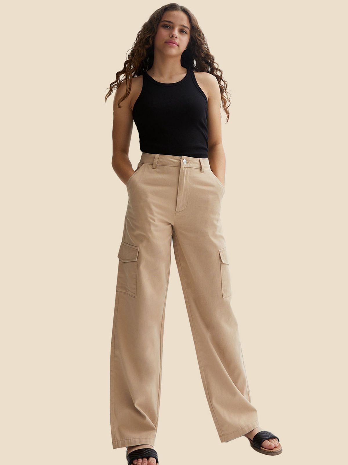 Girl wearing a black vest top and camel wide leg cargos​