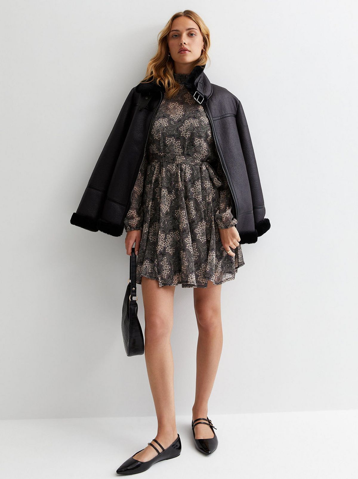 A model wearing a black floral dress. Shop now