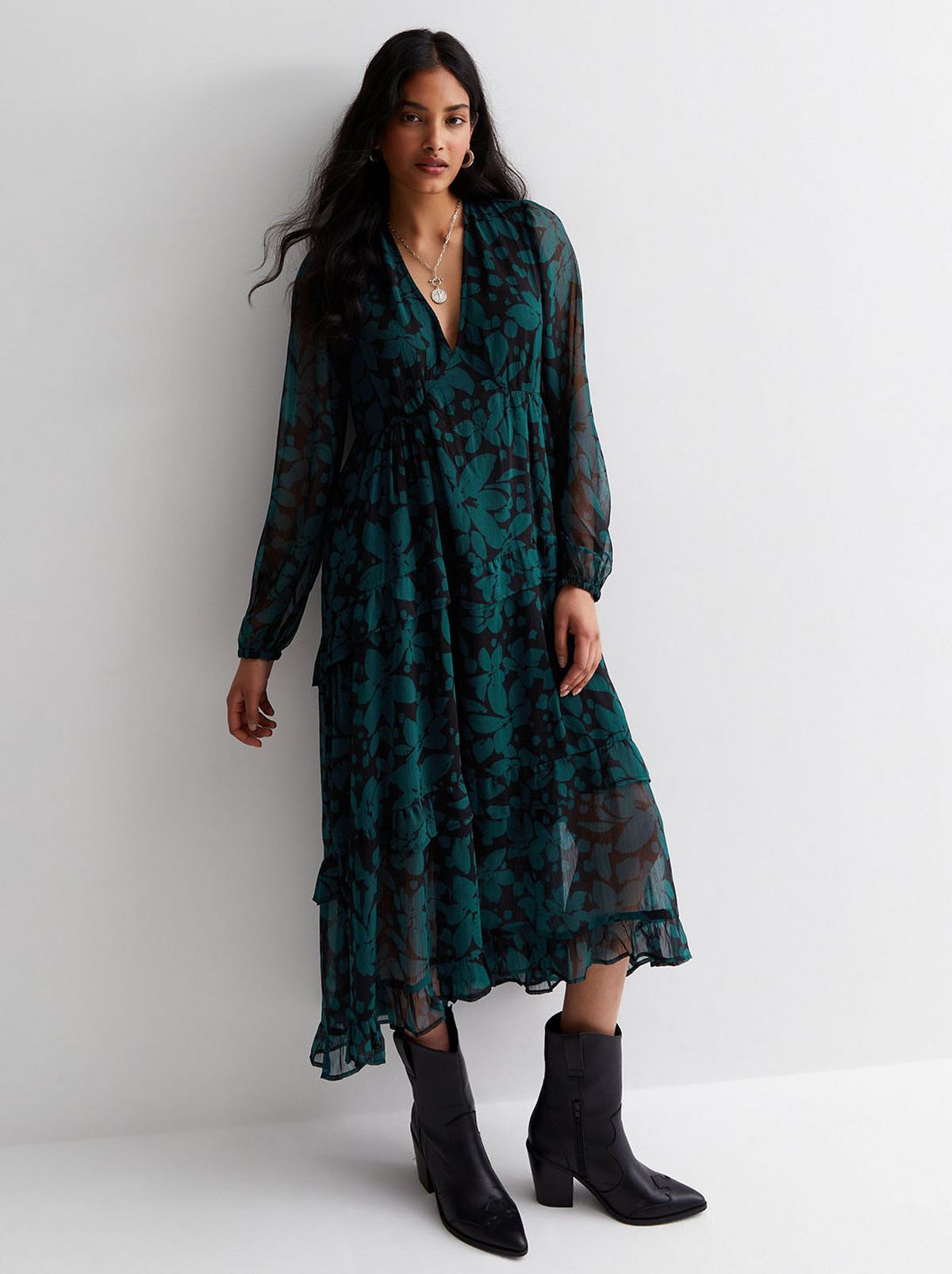 A model wearing a green floral midaxi dress. Shop now