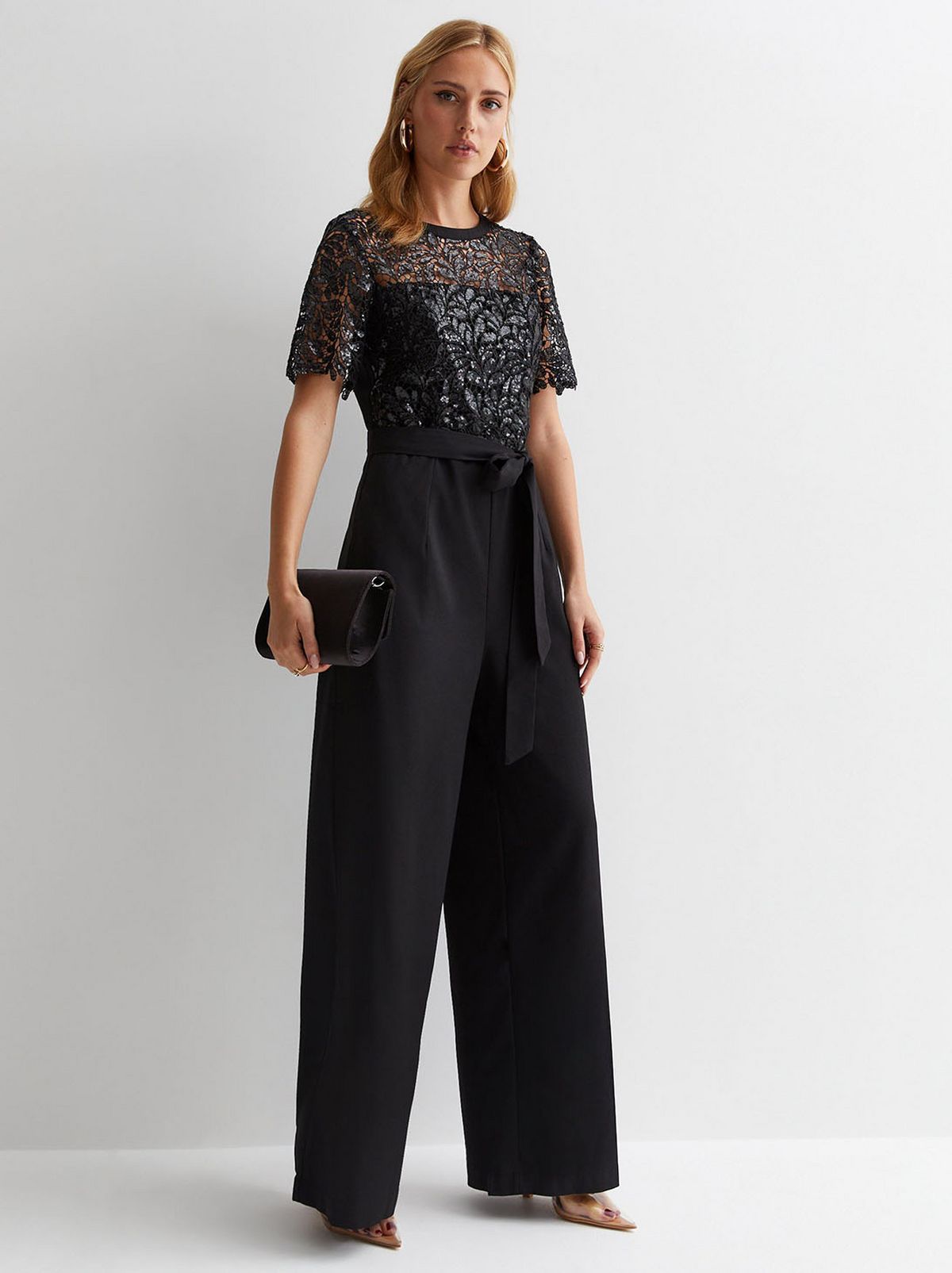 A model wearing a lace floral jumpsuit. Shop now